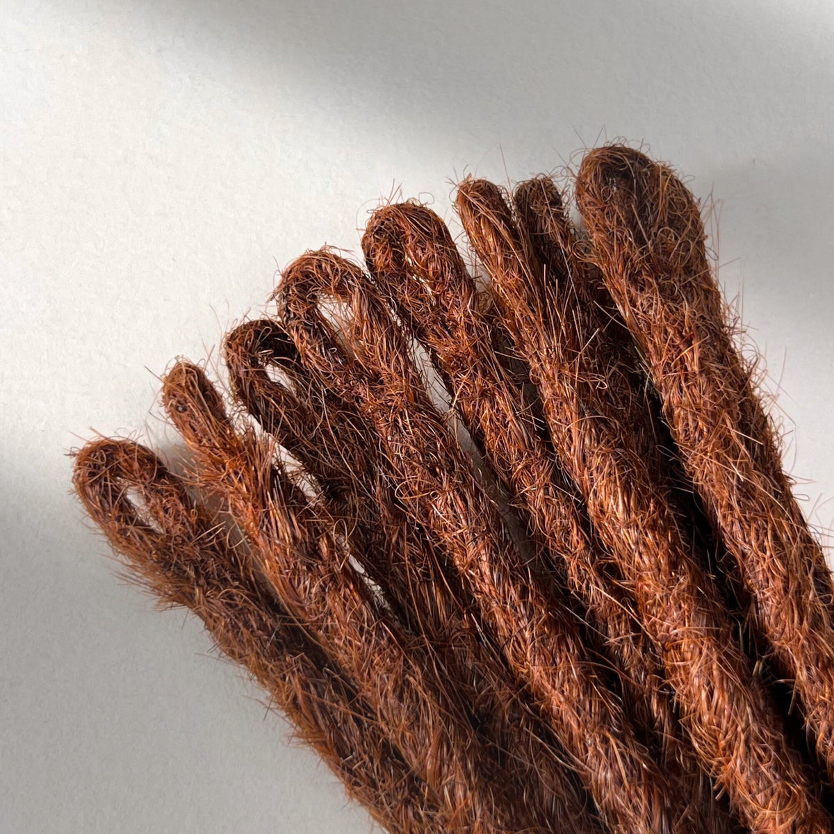Loop detail of temporary single-ended straight loc extensions in Warm Maple Copper.