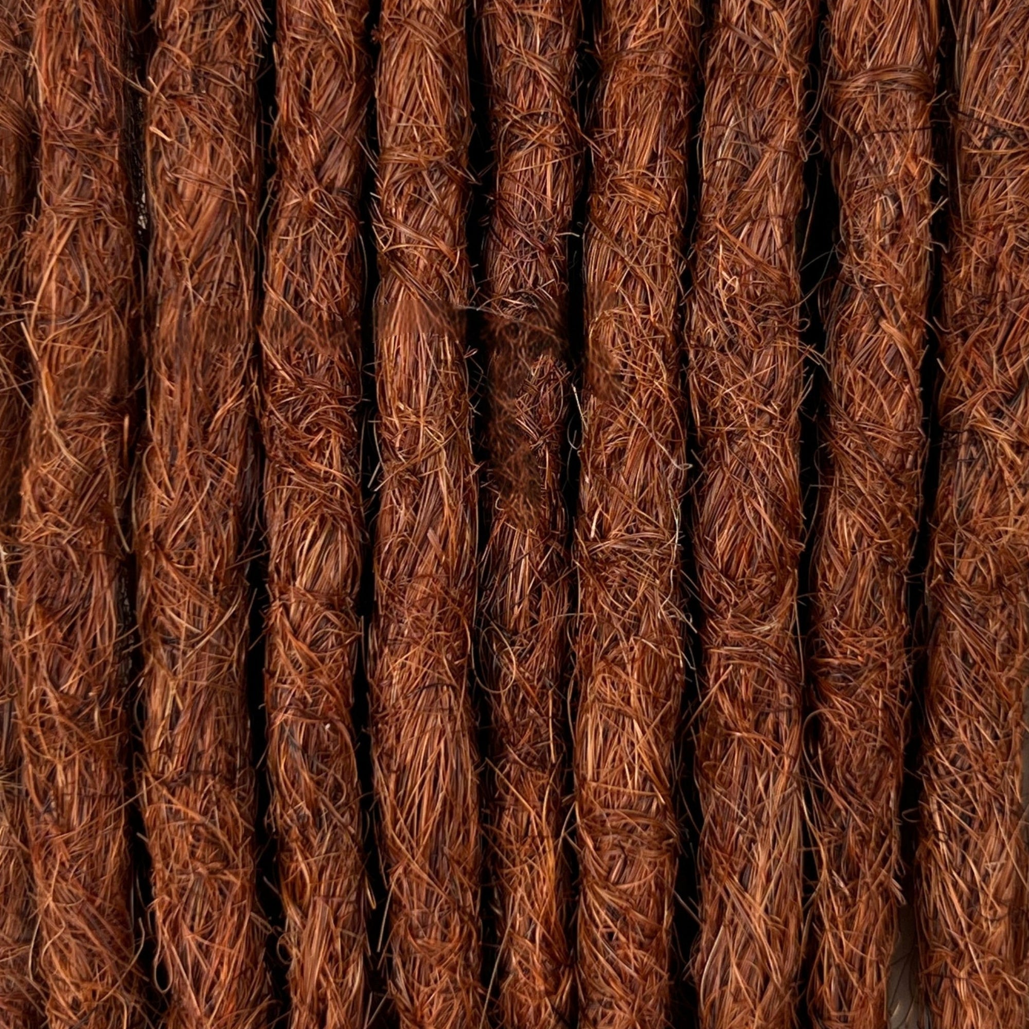 Close-up of straight loc extensions in Warm Maple Copper, showing the texture and color.