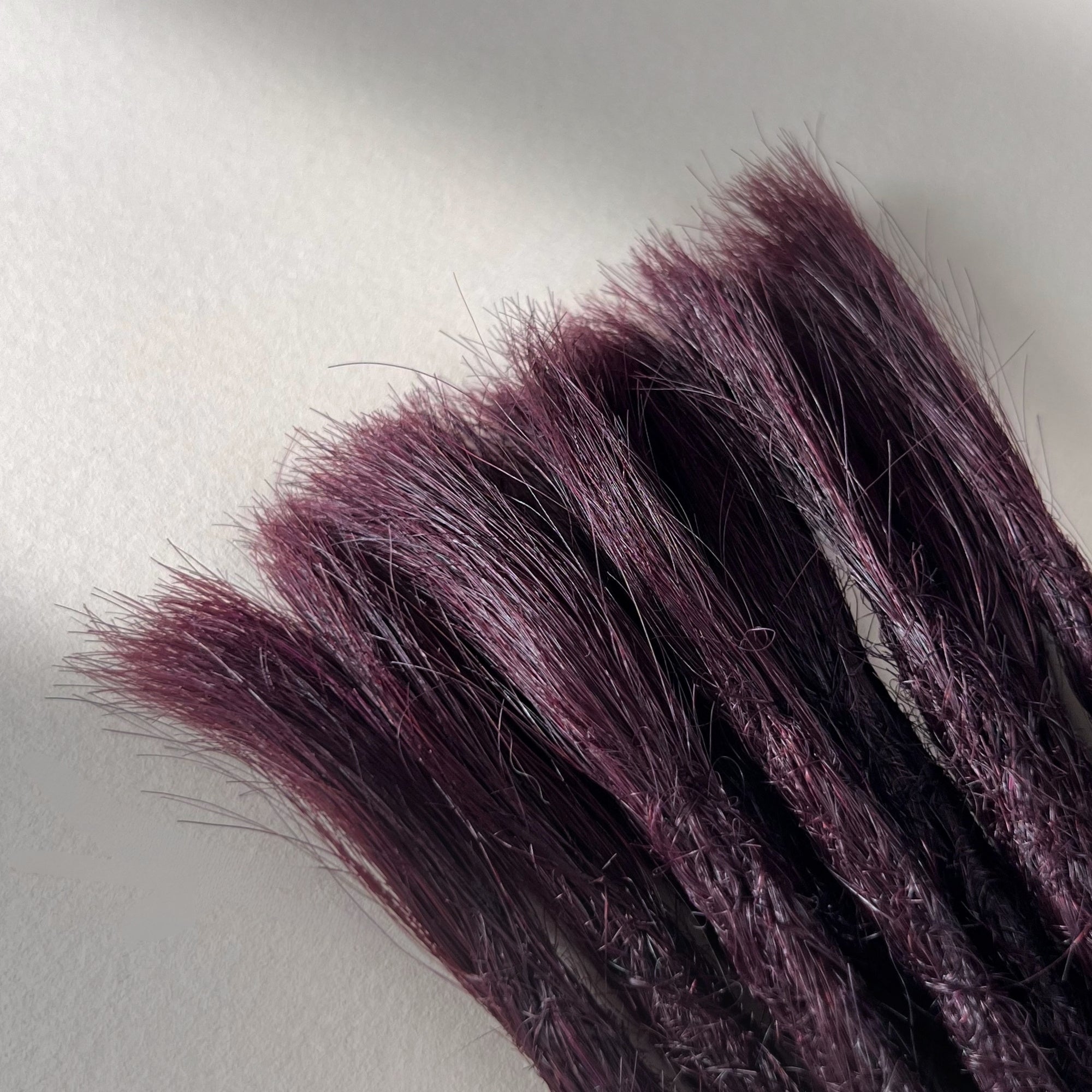 Connection point of permanent straight loc extensions in Warm Marsala Red.