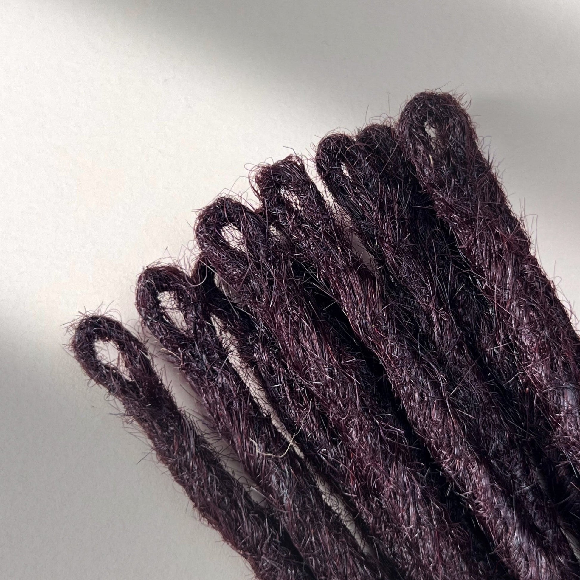 Loop detail of temporary single-ended straight loc extensions in Warm Marsala Red.
