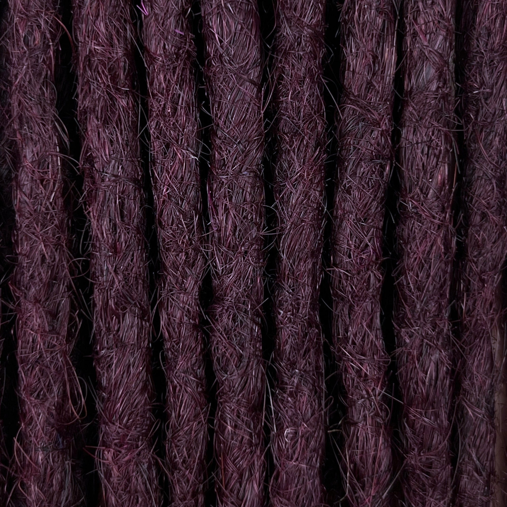 Close-up of straight loc extensions in Warm Marsala Red, showing the texture and color.