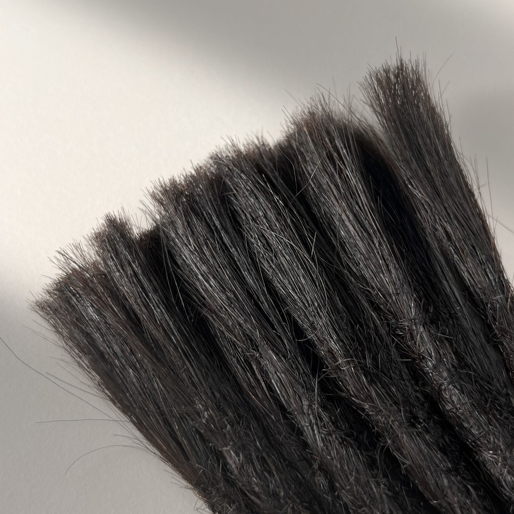 Connection point of permanent straight loc extensions with open ends in Deep Brown.
