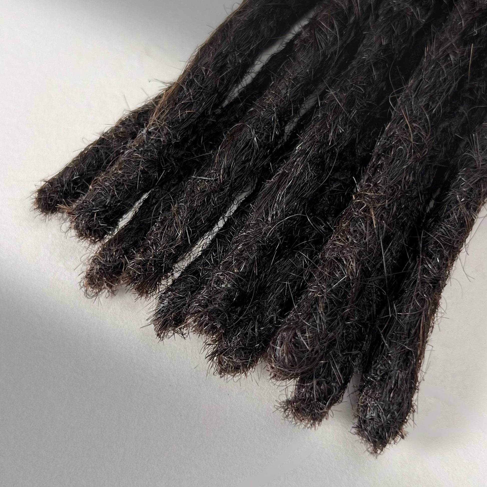 Close-up of the Blunt Ends on handcrafted Straight Human Hair Loc Extensions in Morion for permanent installation.