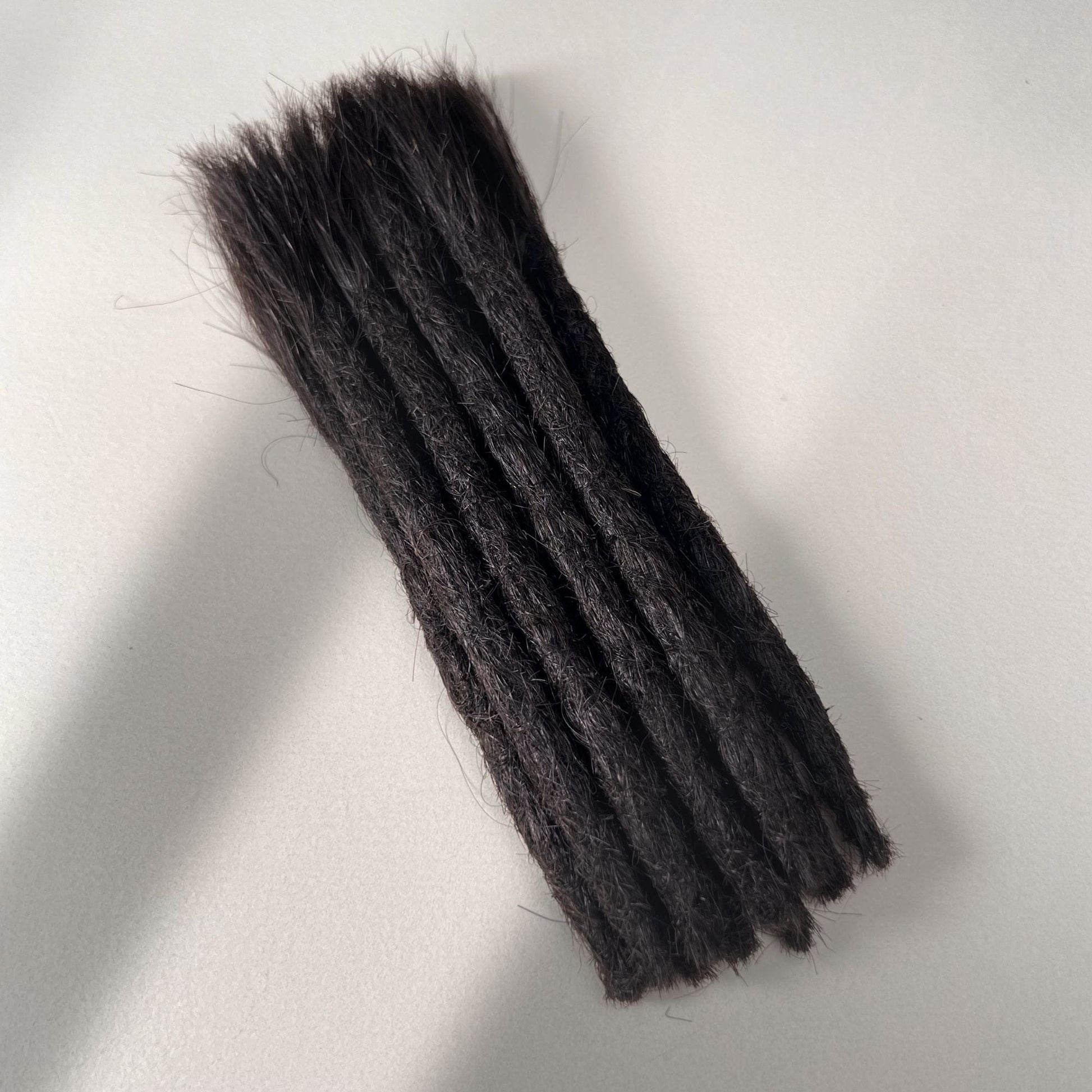 Full view of permanent straight loc extensions with blunt ends in Dark Ash Brown.