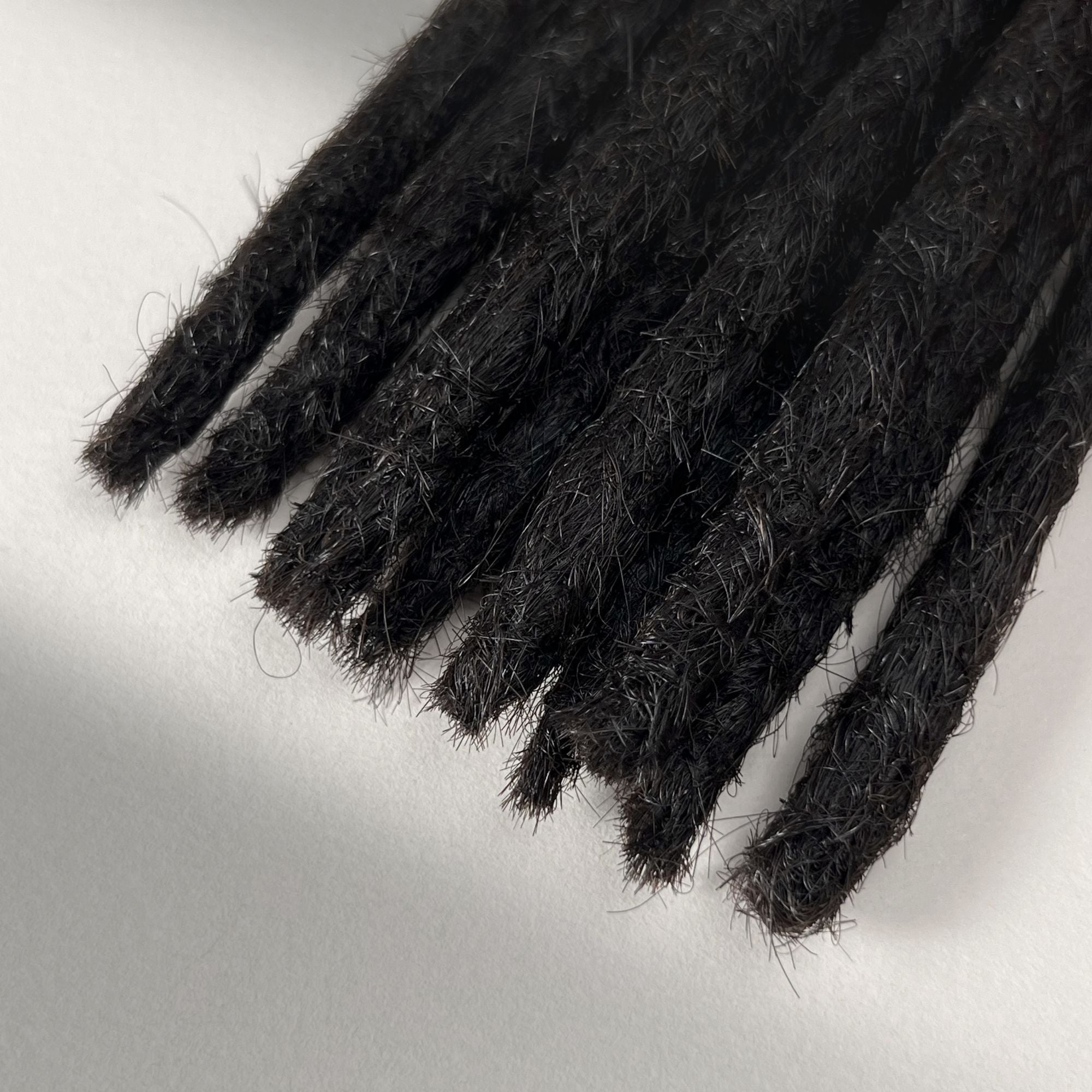 Tip detail of straight loc extensions with blunt ends in Dark Ash Brown.