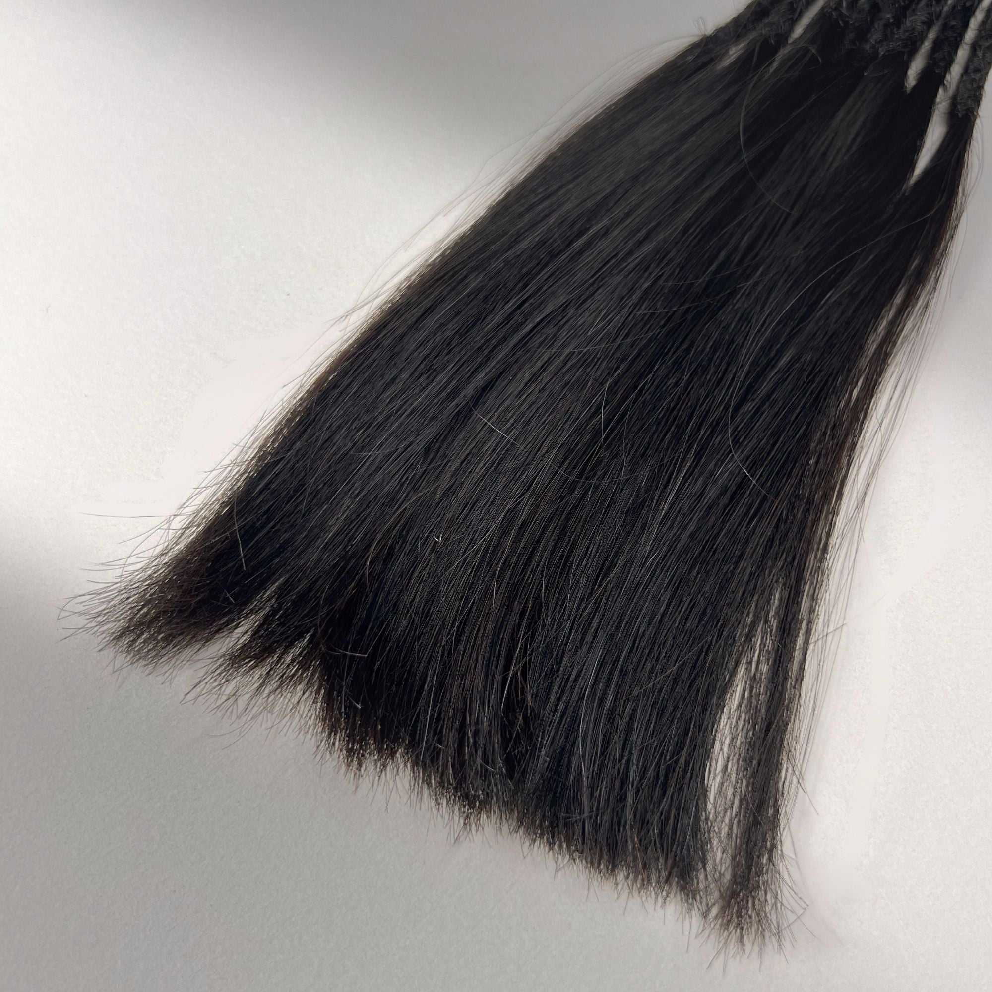 Tip detail of straight loc extensions with long loose ends in Dark Ash Brown.