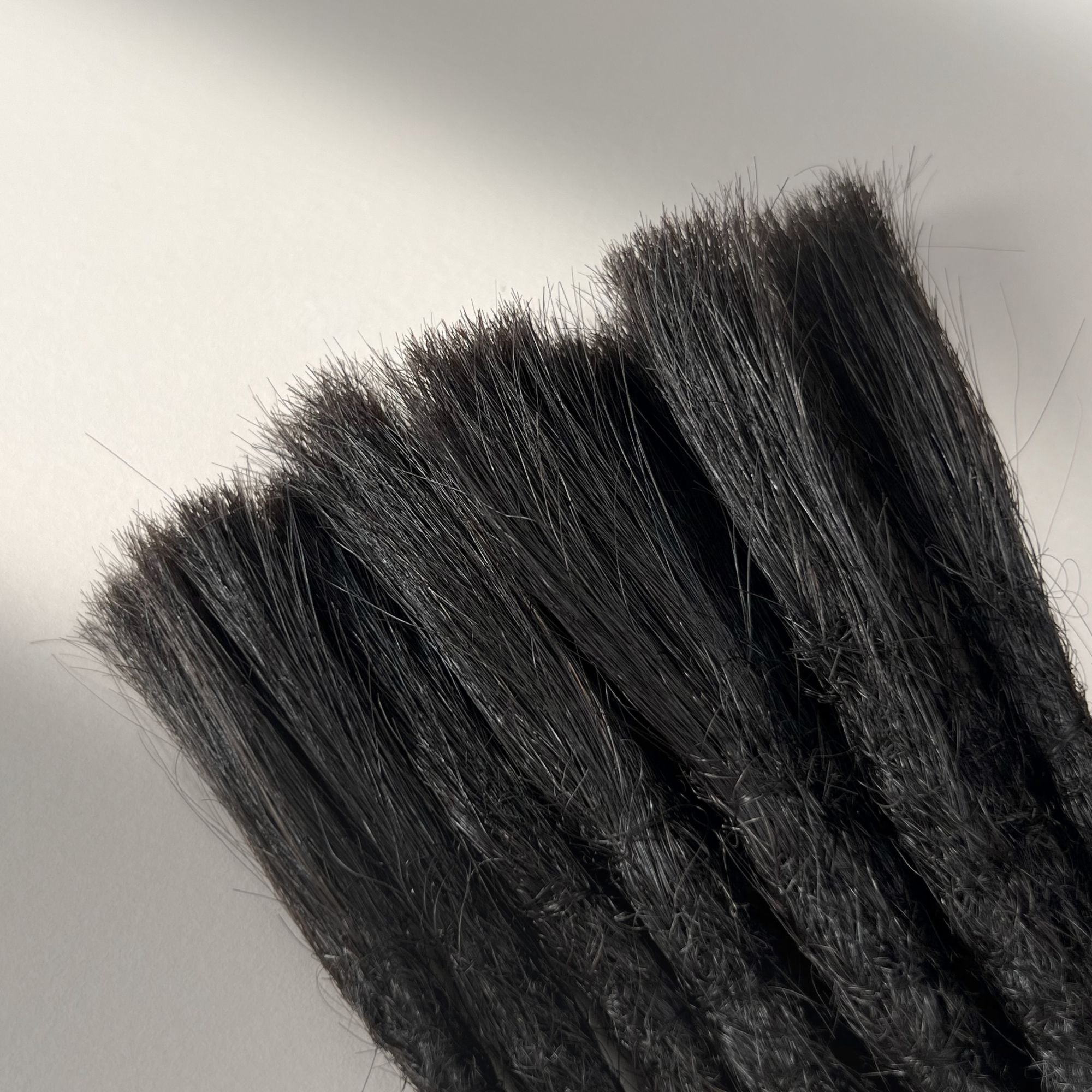Connection point of permanent straight loc extensions with open ends in Dark Ash Brown.