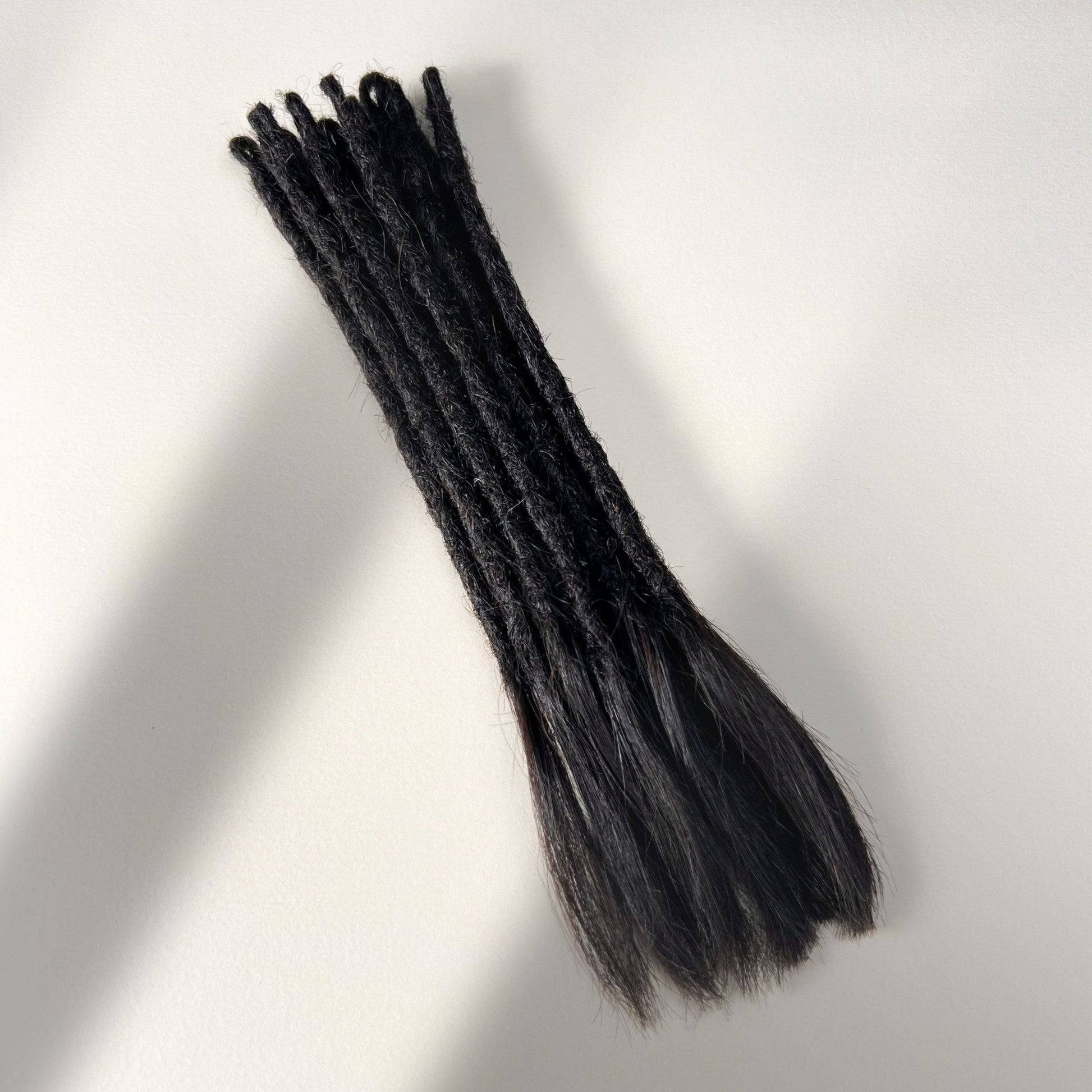 Full view of temporary single-ended straight loc extensions with open ends in Dark Ash Brown.
