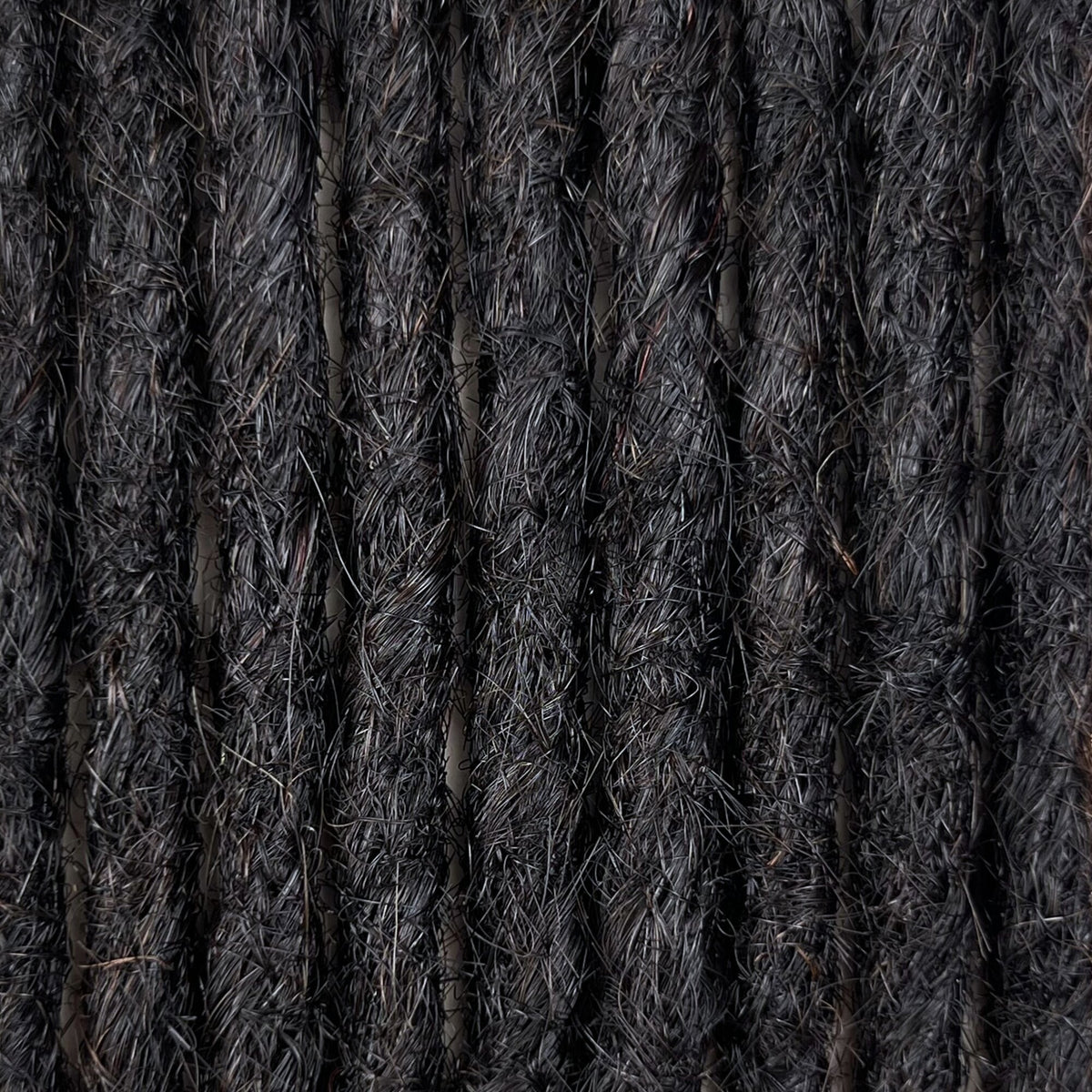 Close-up of straight loc extensions in Dark Ash Brown, showing the texture and color.