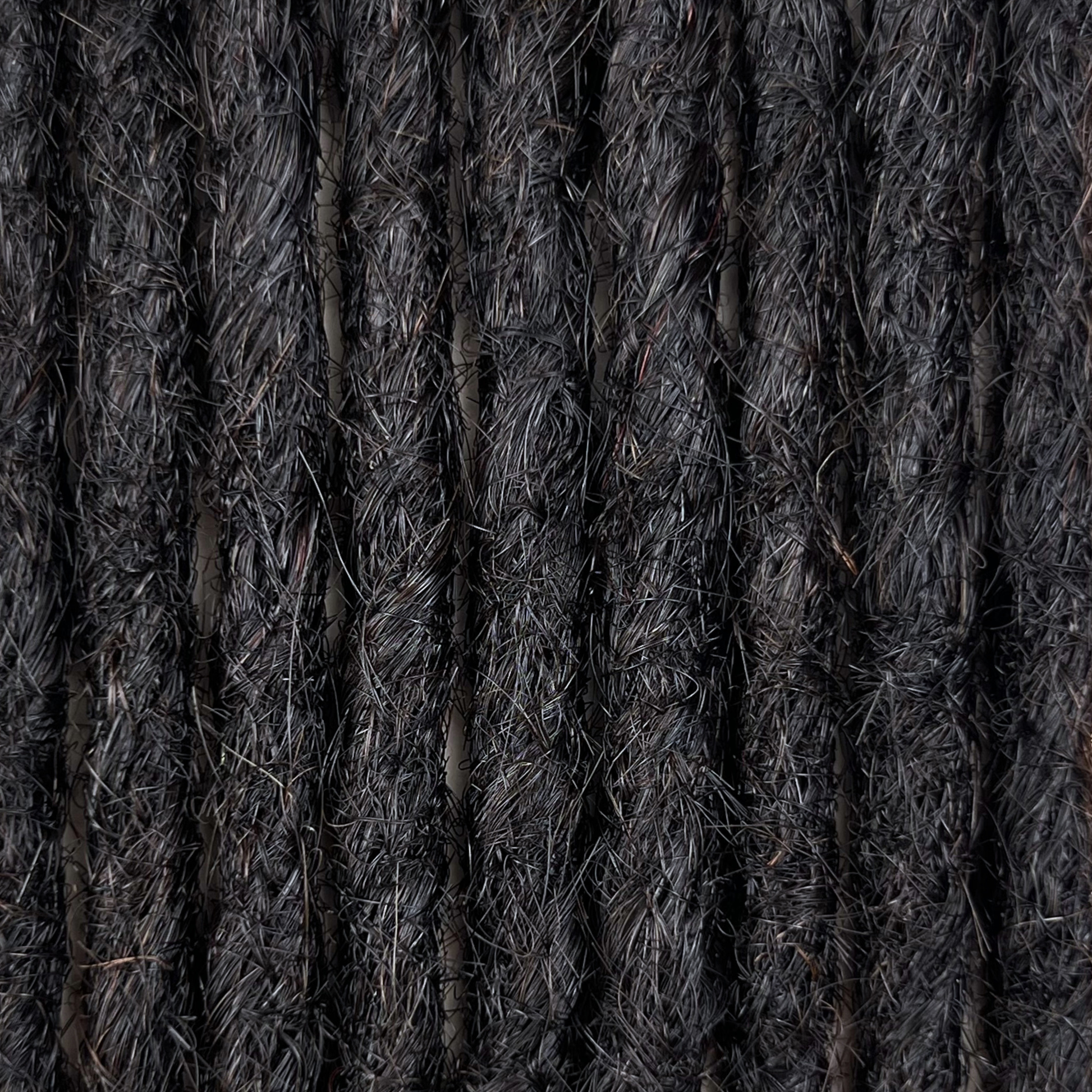 Close-up of straight loc extensions in Dark Ash Brown, showing the texture and color.