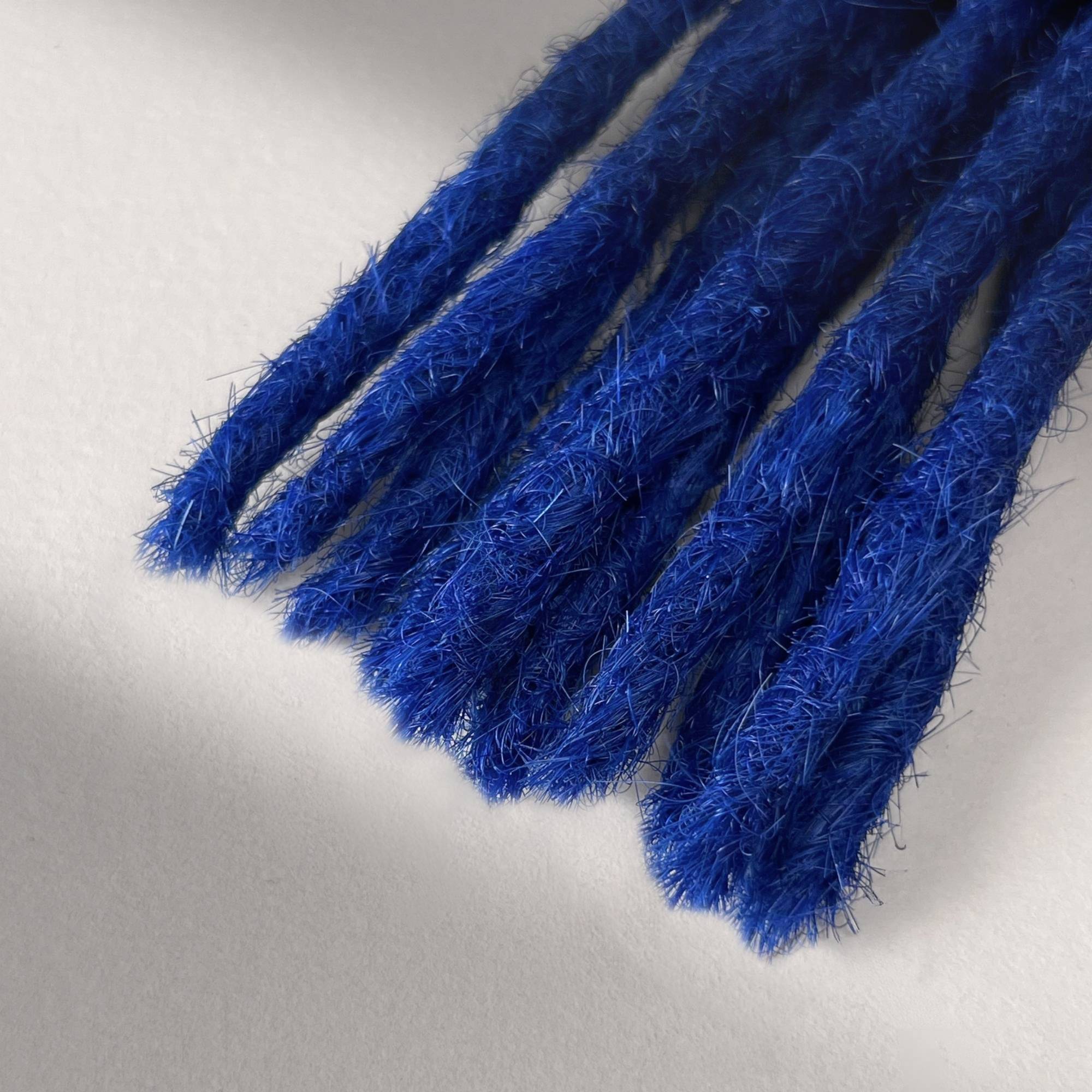 Tip detail of straight loc extensions with blunt ends in Deep Navy Blue.