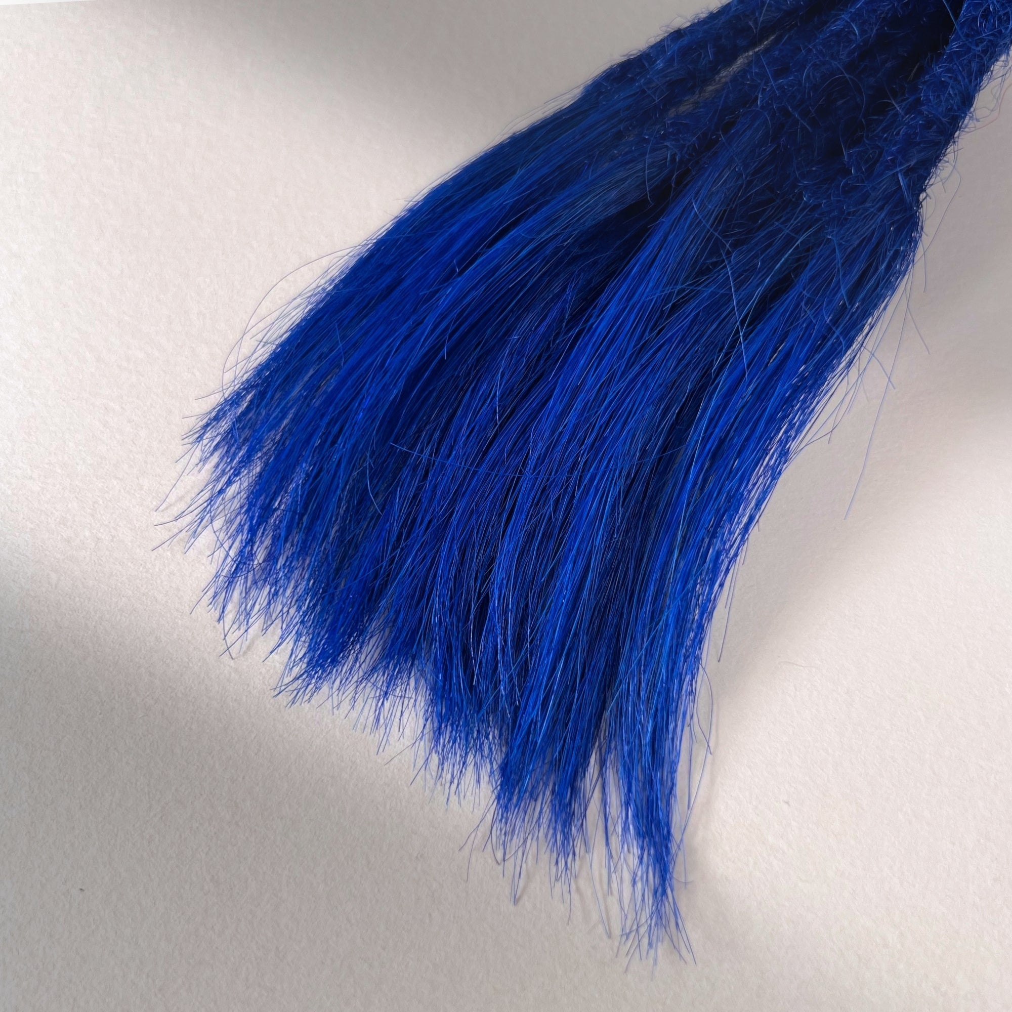 Tip detail of straight loc extensions with open ends in Deep Navy Blue.