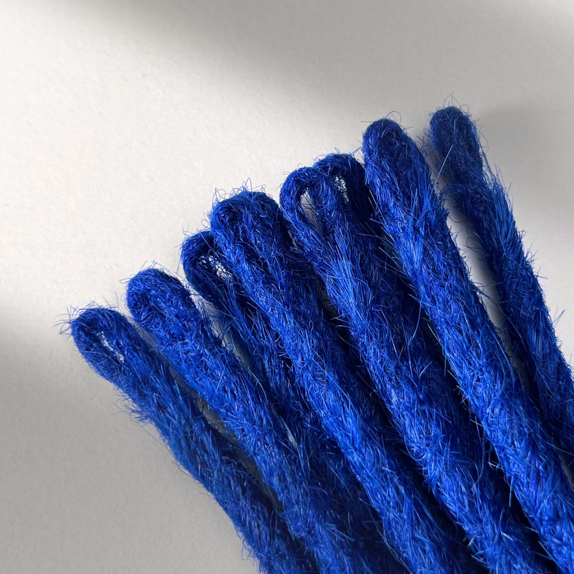 Loop detail of temporary single-ended straight loc extensions in Deep Navy Blue.