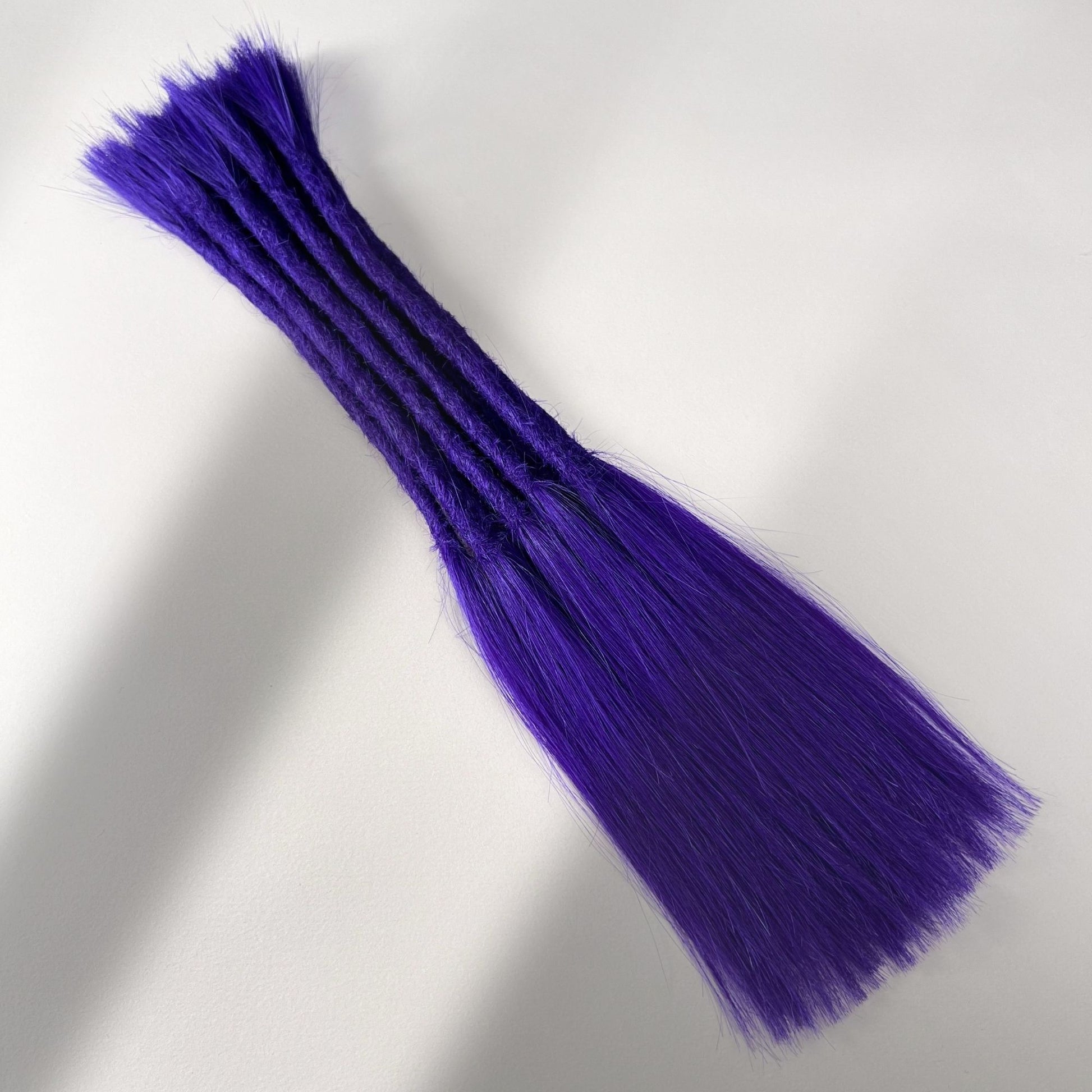 Full view of permanent straight loc extensions with long loose ends in Orchid Violet.