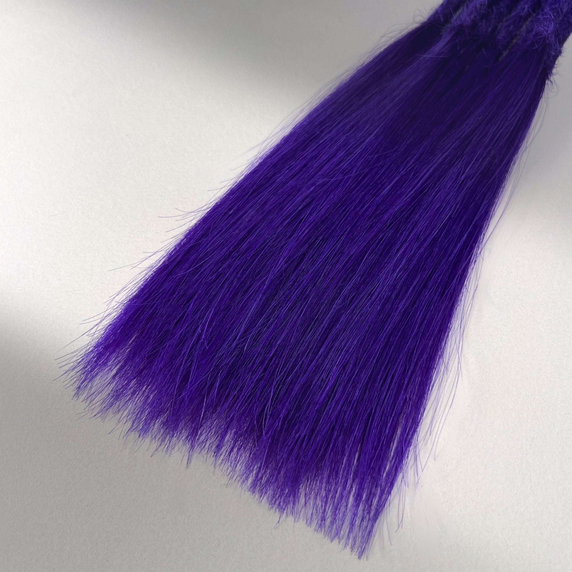 Tip detail of straight loc extensions with long loose ends in Orchid Violet.