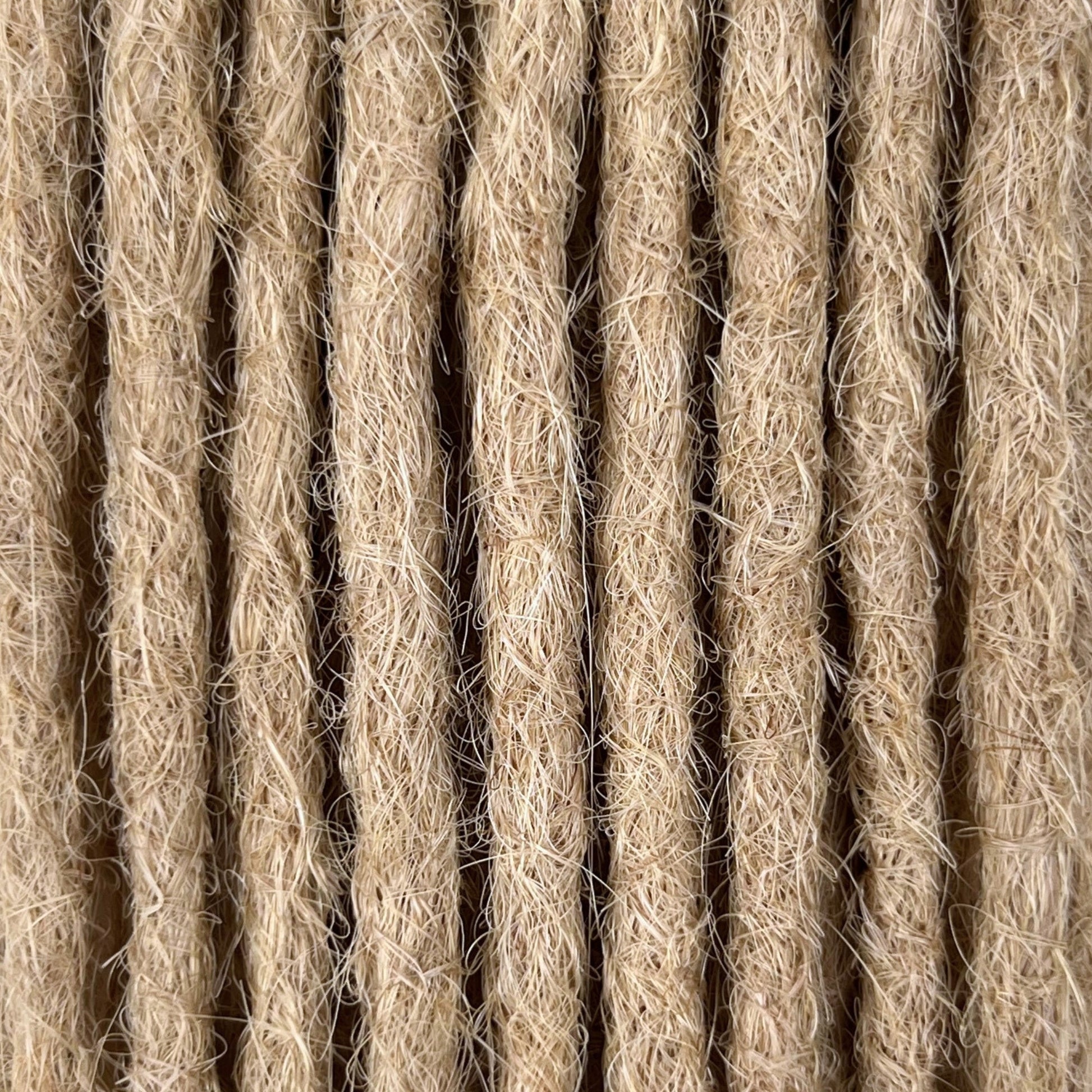 Close-up of straight loc extensions in Cream Blonde, showing the texture and color.