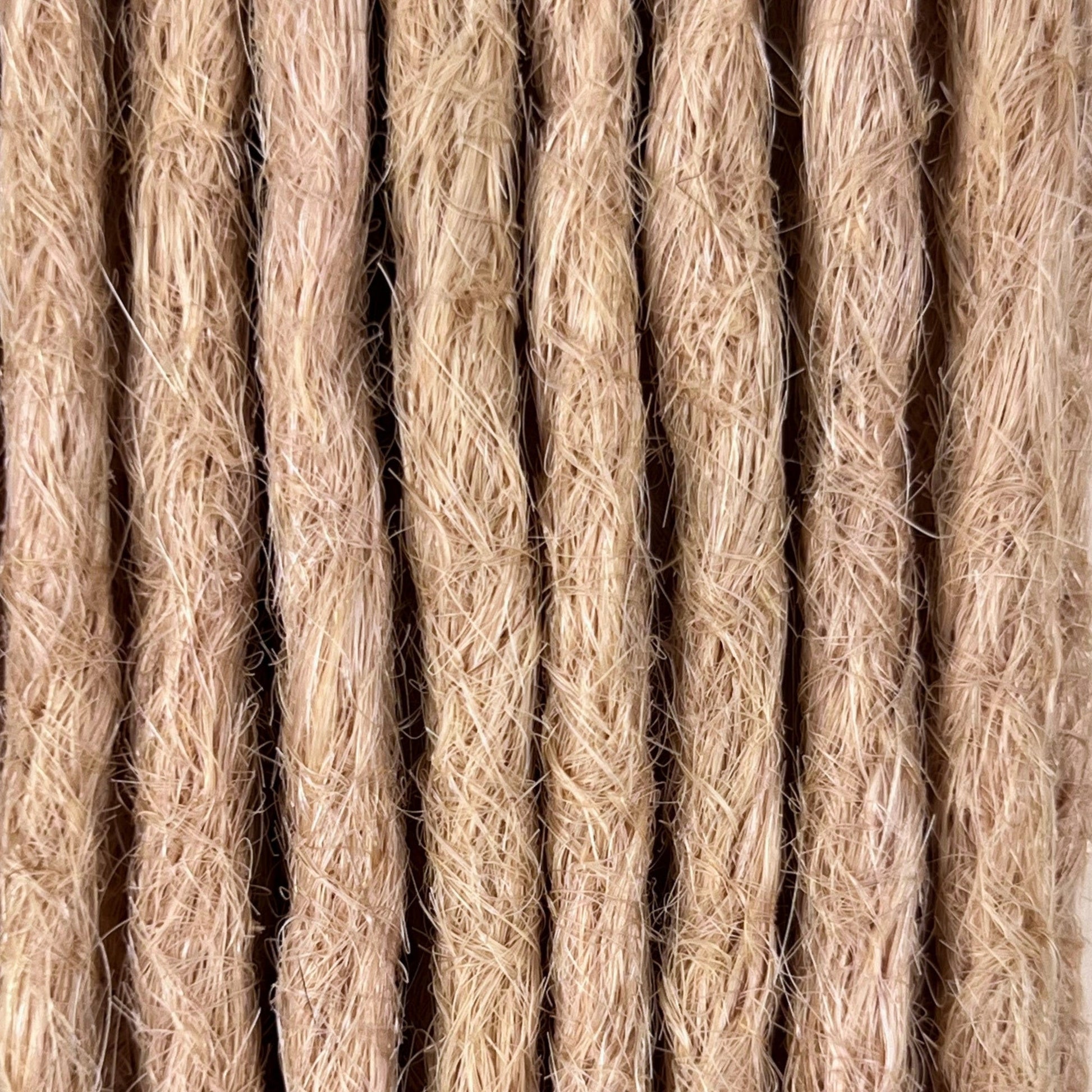 Close-up of straight loc extensions in Soft Rose Blonde, showing the texture and color.