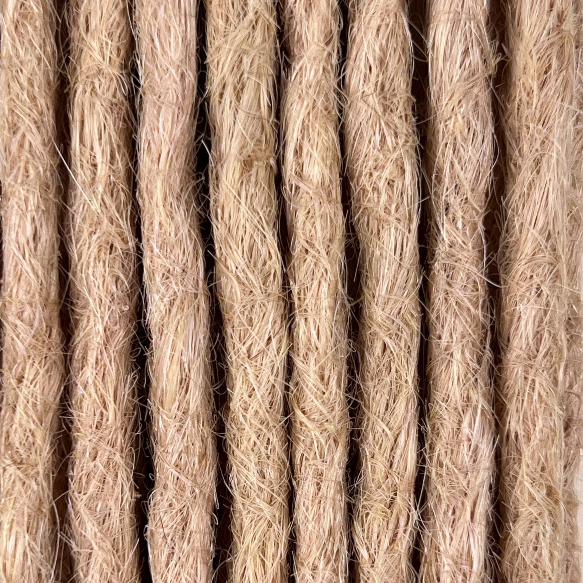 Close-up of straight loc extensions in Soft Rose Blonde, showing the texture and color.