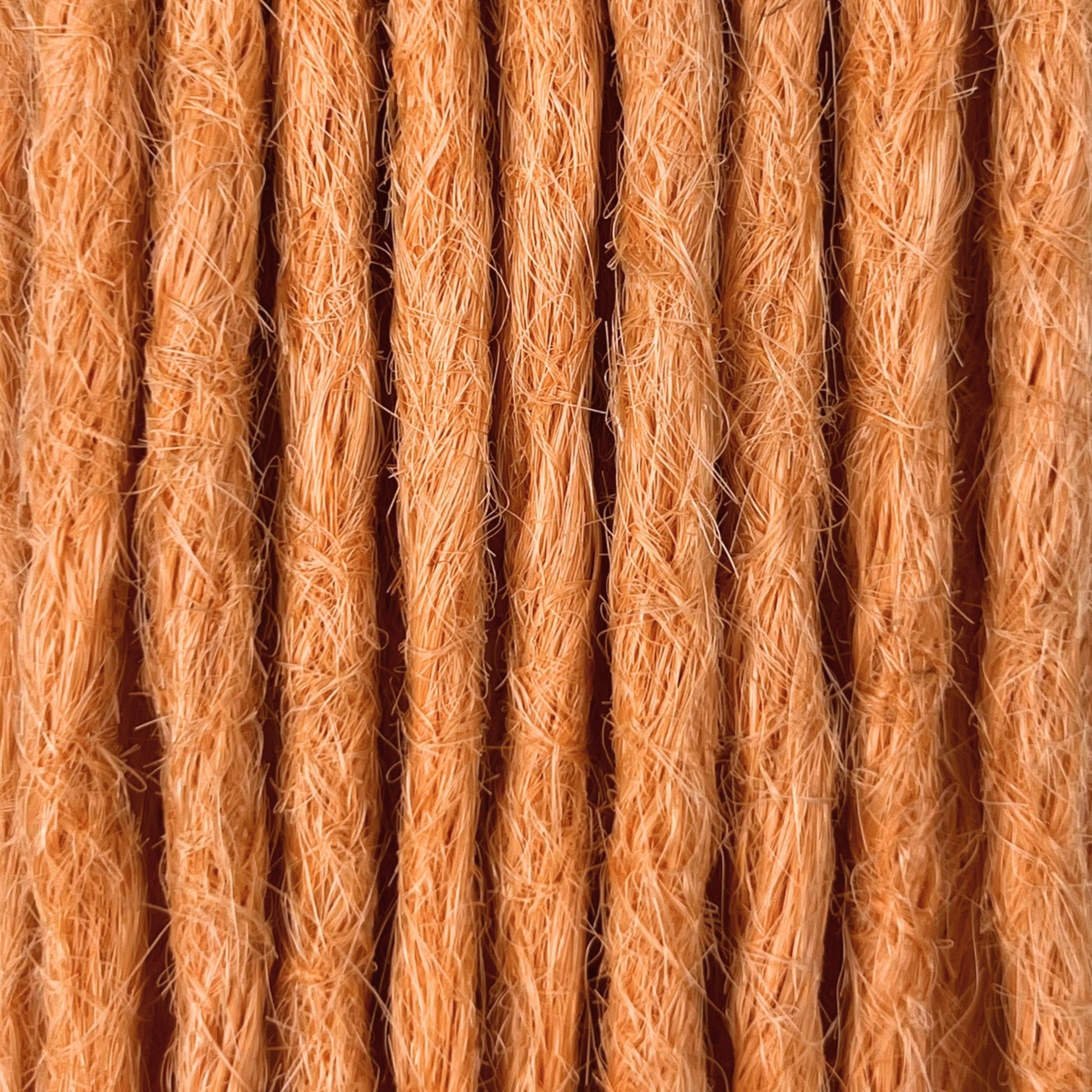 Close-up of straight loc extensions in Peach Orange, showing the texture and color.