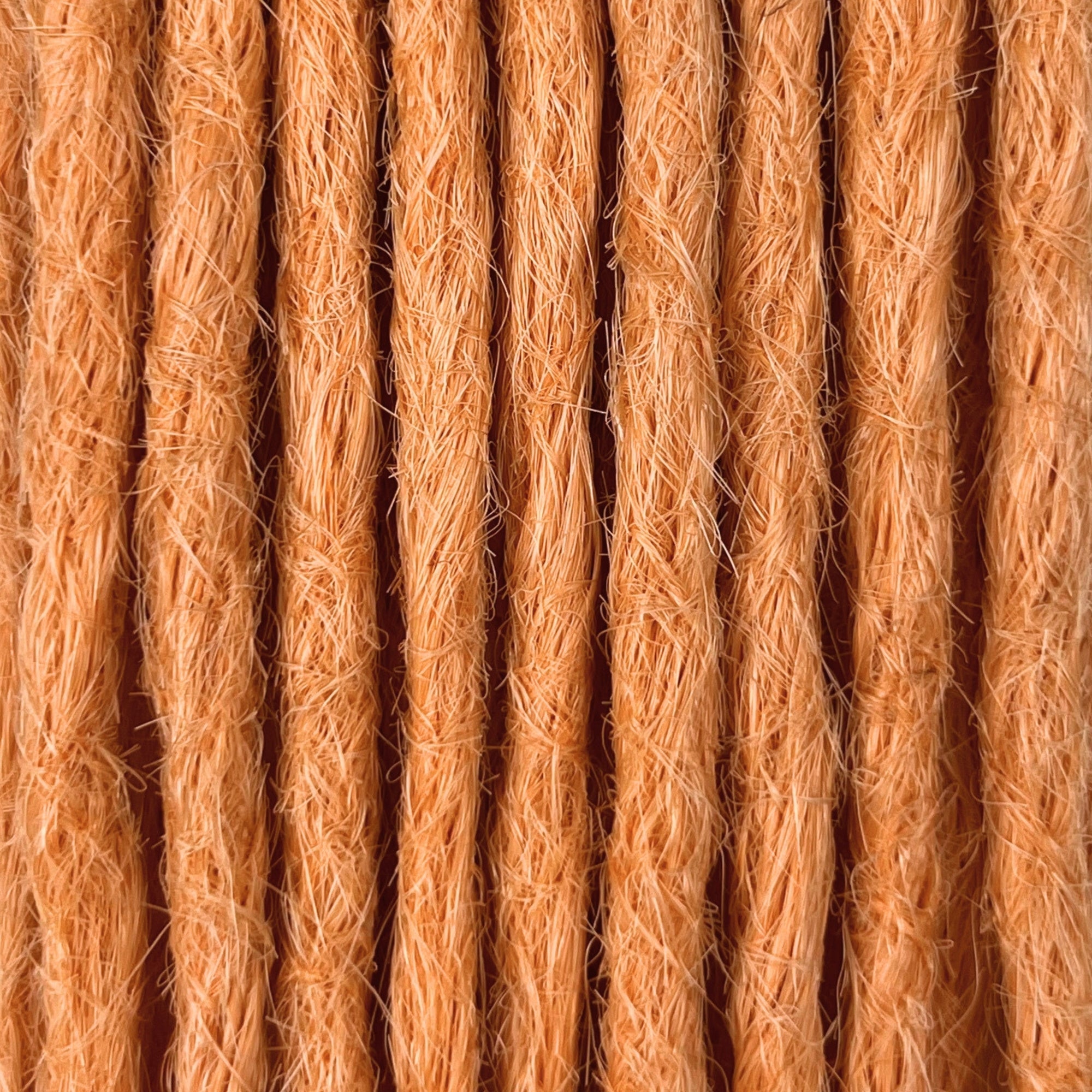 Close-up of straight loc extensions in Peach Orange, showing the texture and color.