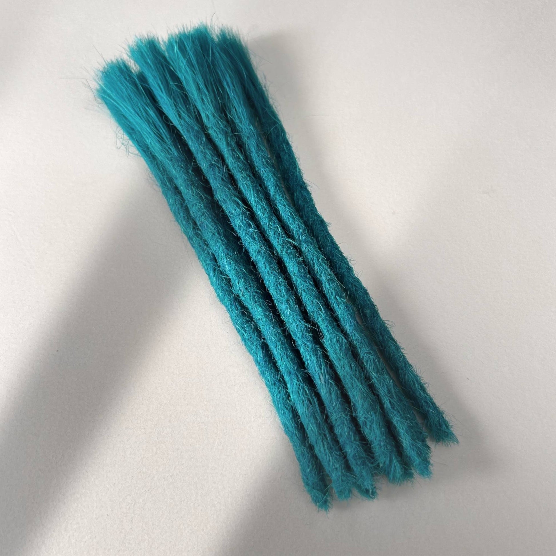 Full view of permanent straight loc extensions with blunt ends in Frost Blue.