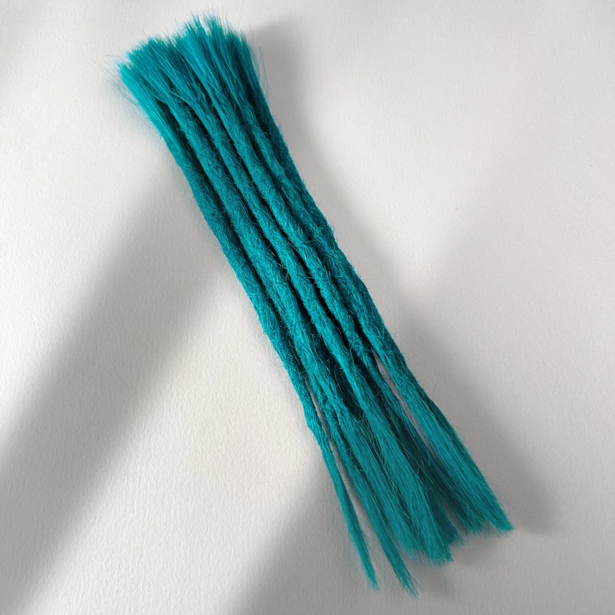 Full view of permanent straight loc extensions with open ends in Frost Blue.