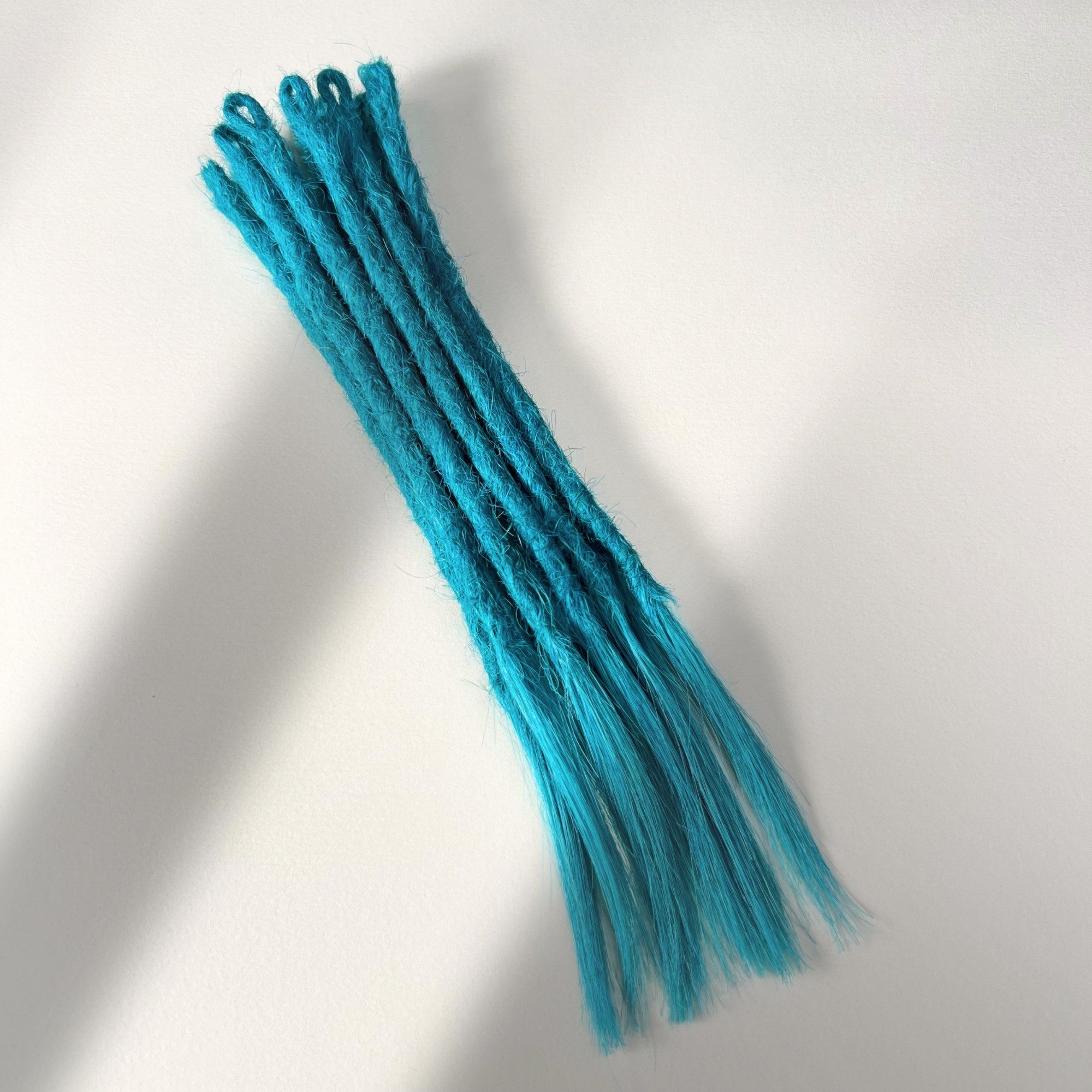 Full view of temporary single-ended straight loc extensions with open ends in Frost Blue.