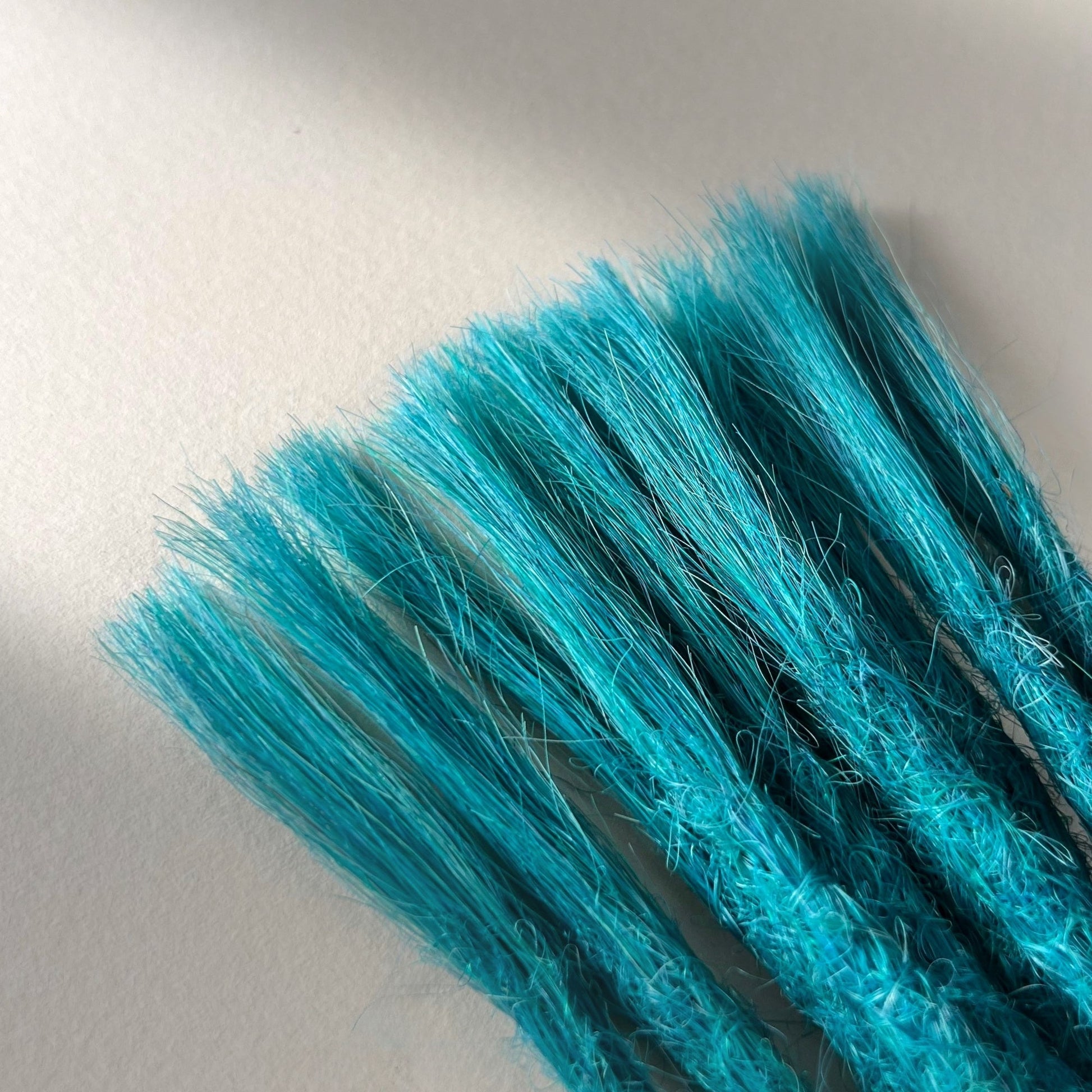 Connection point of permanent straight loc extensions in Frost Blue.
