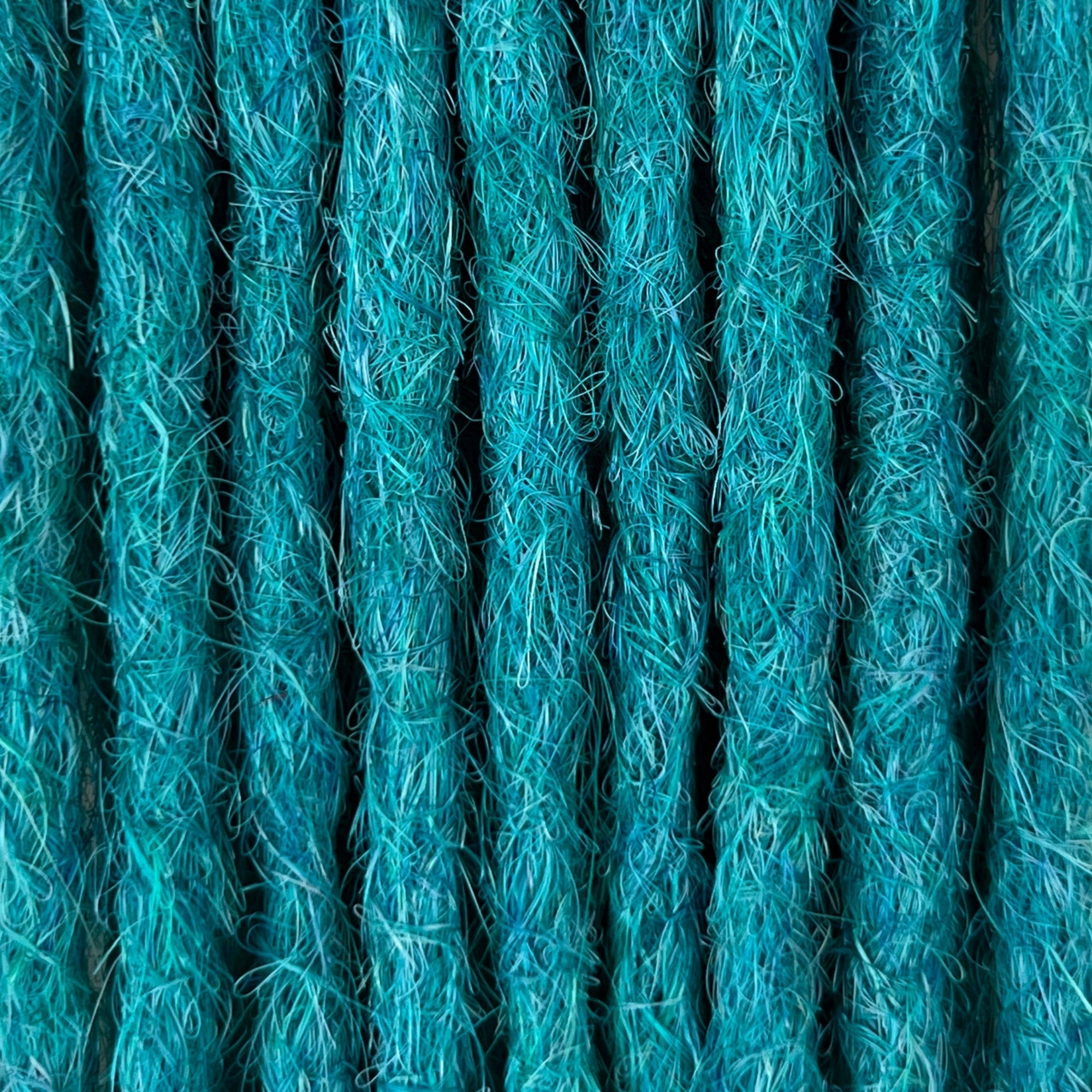 Close-up of straight loc extensions in Frost Blue, showing the texture and color.