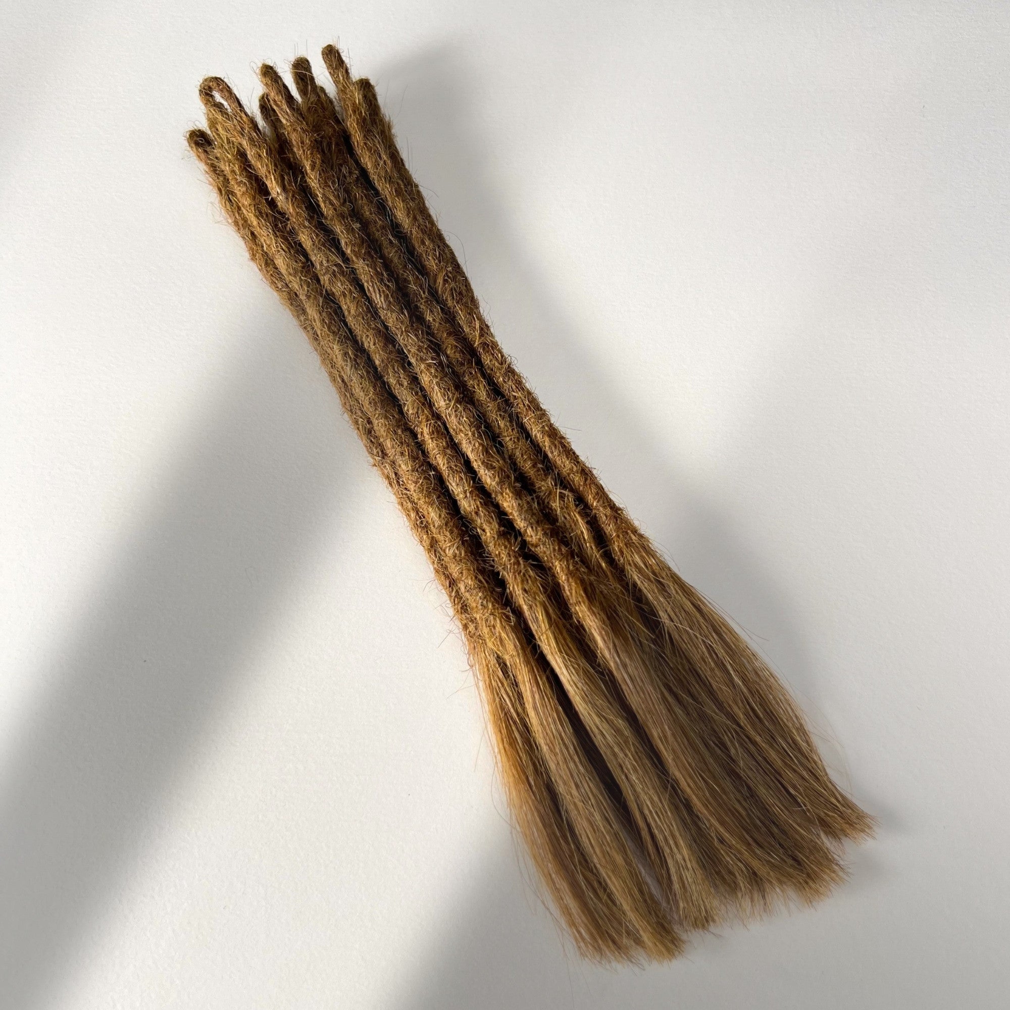 Full view of temporary single-ended straight loc extensions with open ends in Warm Chestnut Brown.