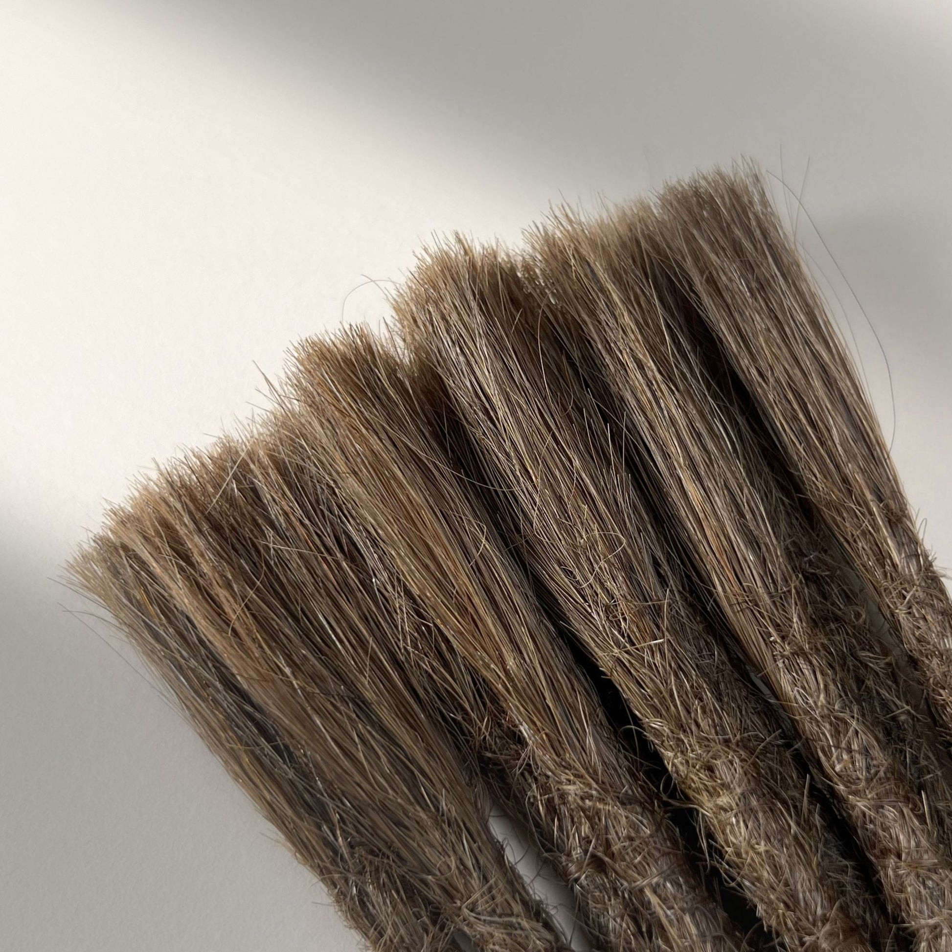 Connection point of permanent straight loc extensions with open ends in Natural Medium Brown.