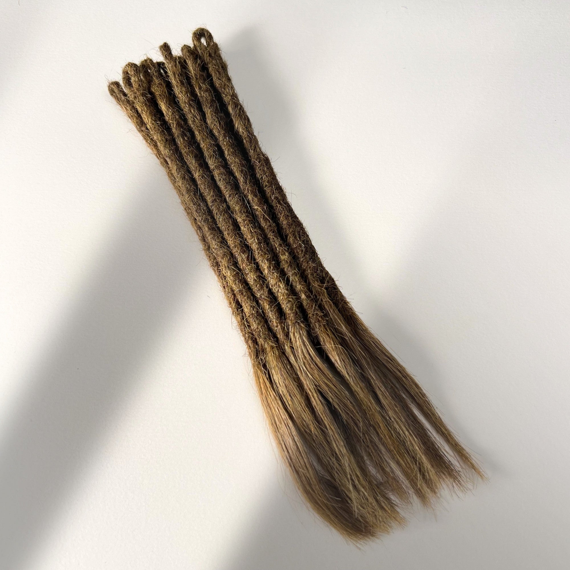 Full view of temporary single-ended straight loc extensions with open ends in Natural Medium Brown.