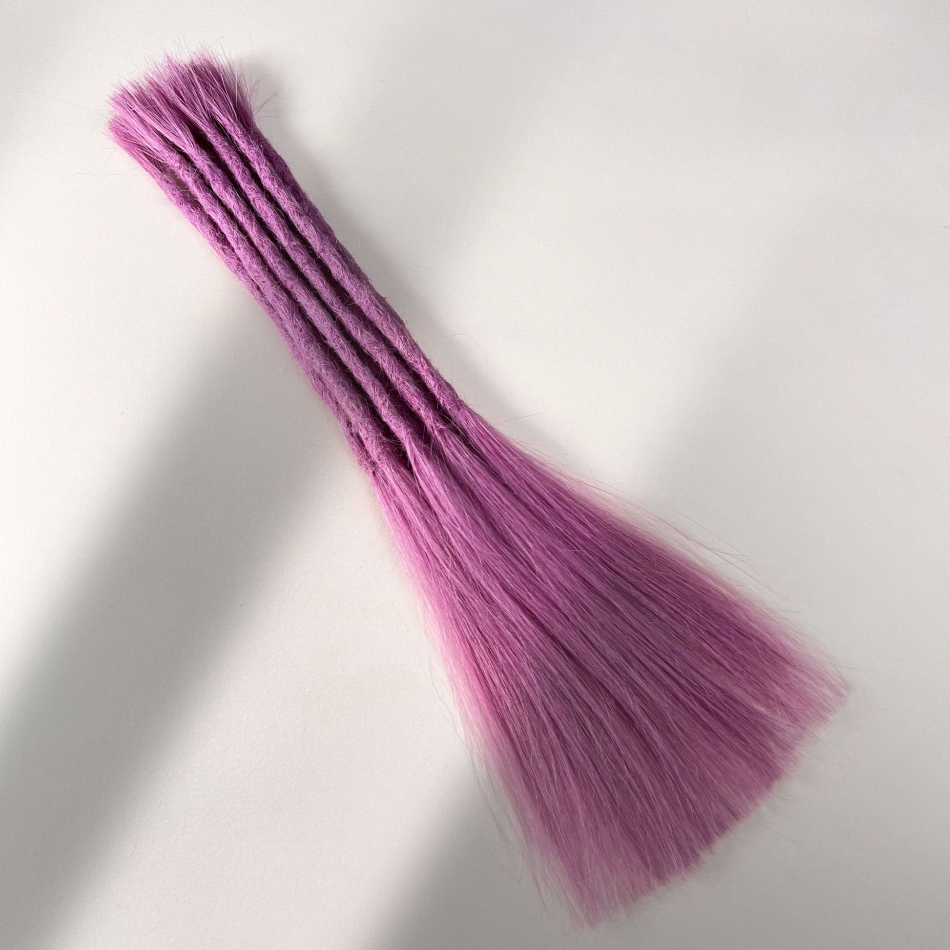 Full view of permanent straight loc extensions with long loose ends in Lavender Purple.