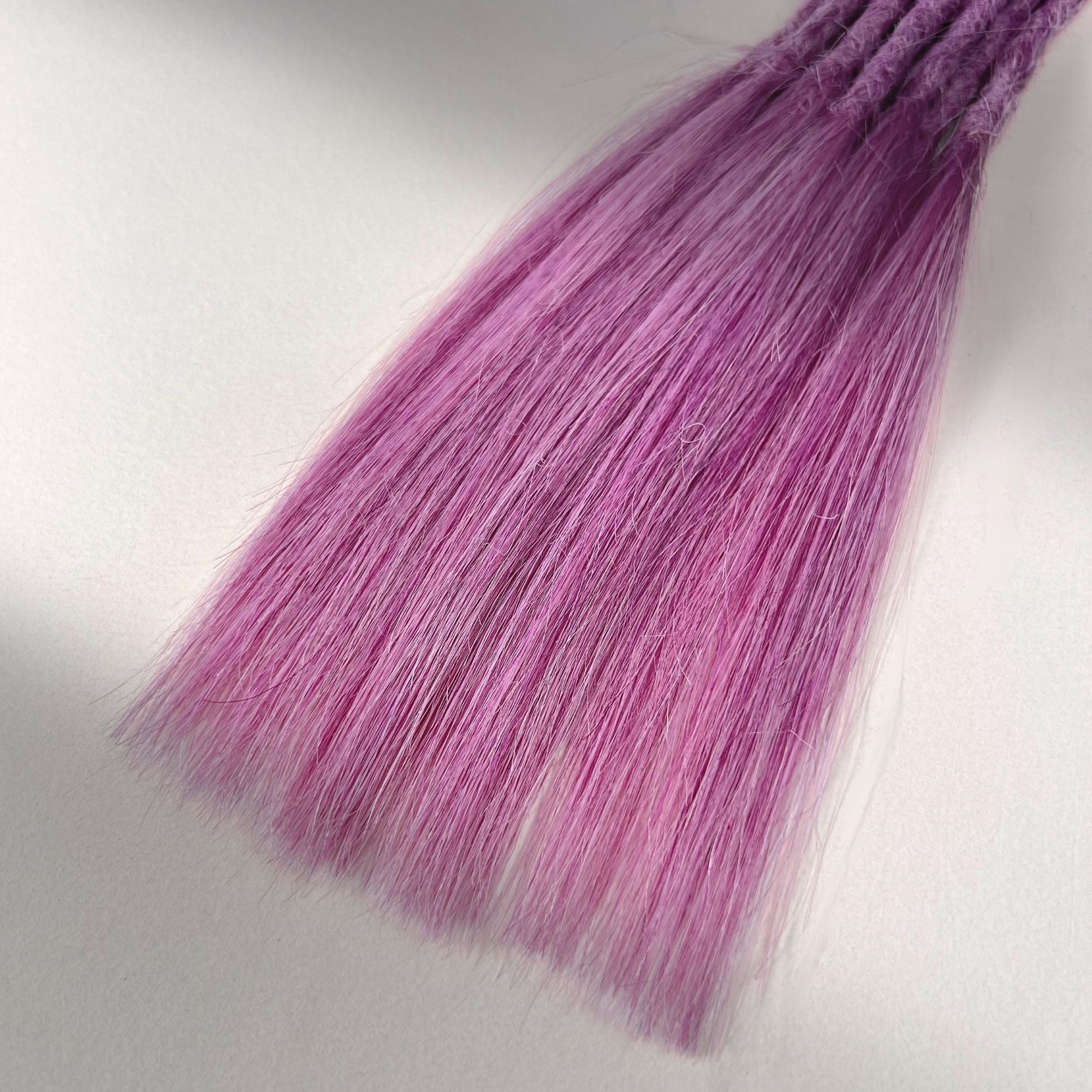 Tip detail of straight loc extensions with long loose ends in Lavender Purple.