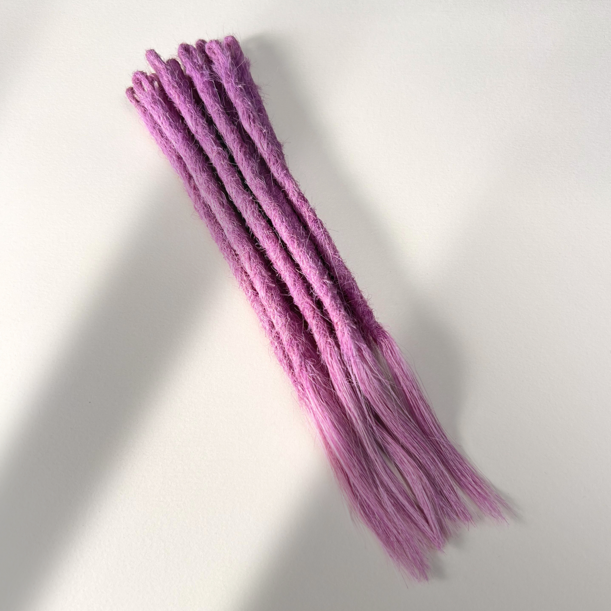 Full view of temporary single-ended straight loc extensions with open ends in Lavender Purple.
