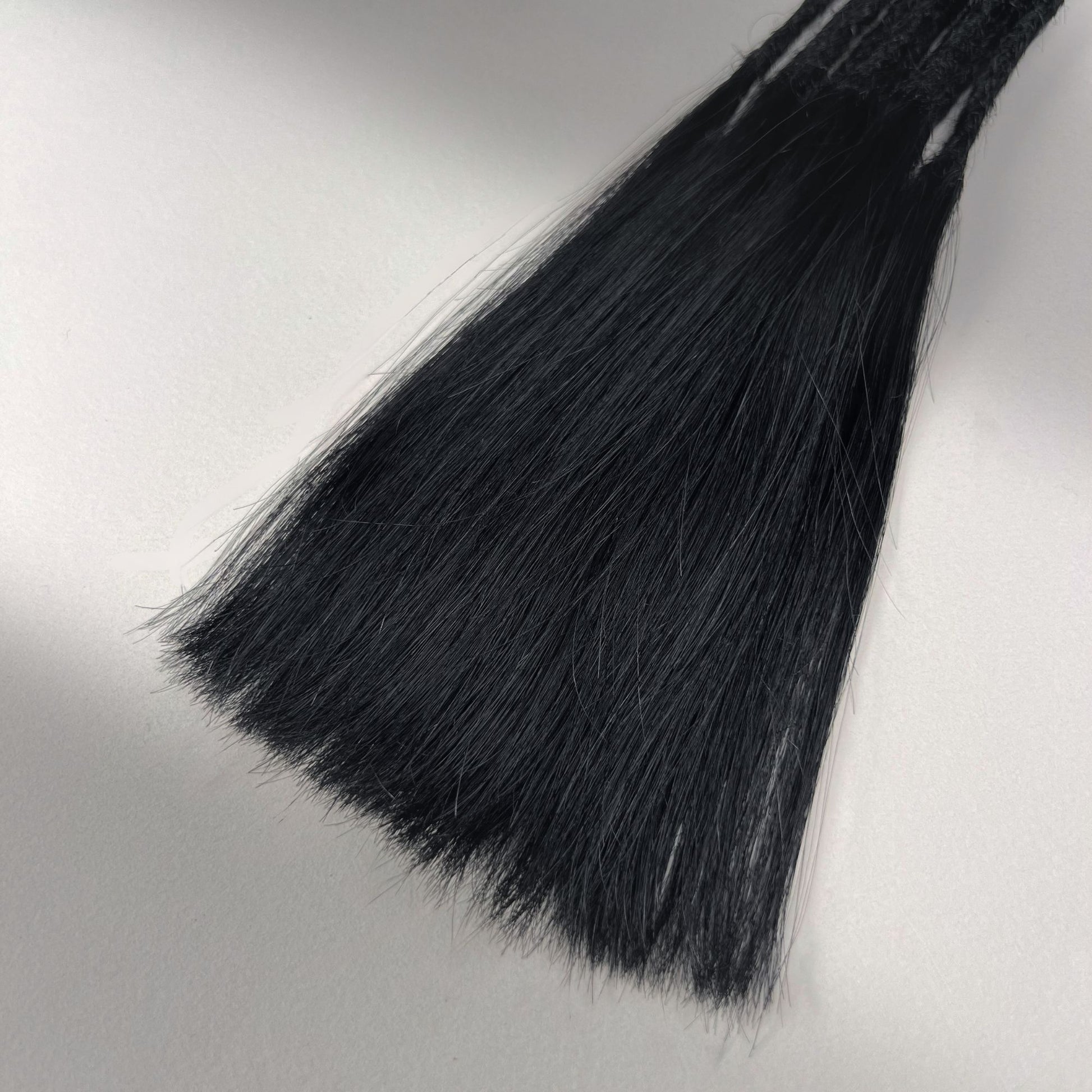Tip detail of straight loc extensions with long loose ends in Deepest Black.