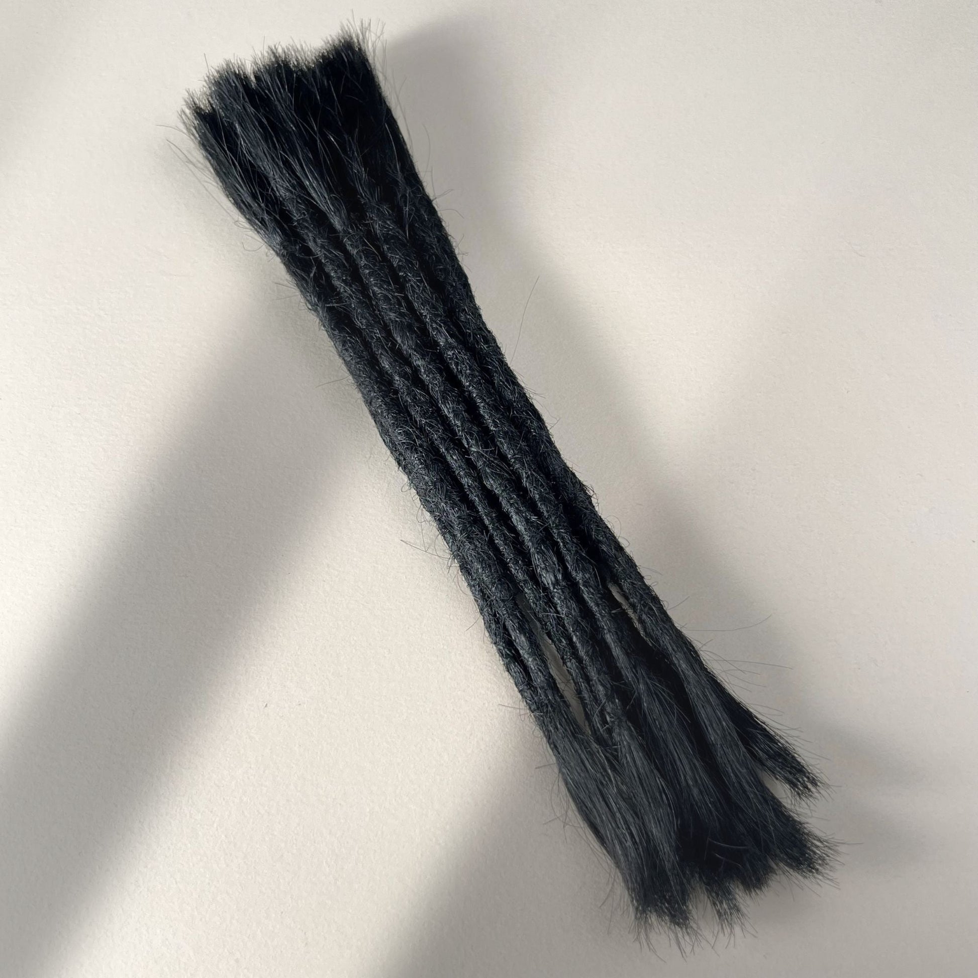 Full view of straight loc extensions with open ends in Deepest Black for permanent installation.