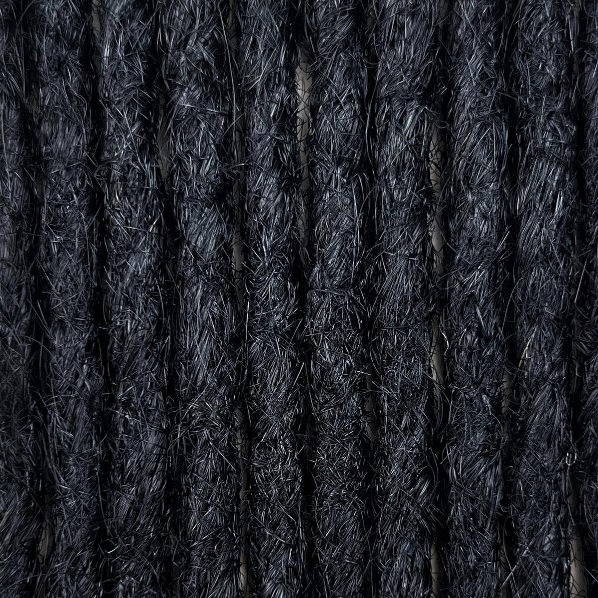 Texture detail of straight loc extensions in Deepest Black.