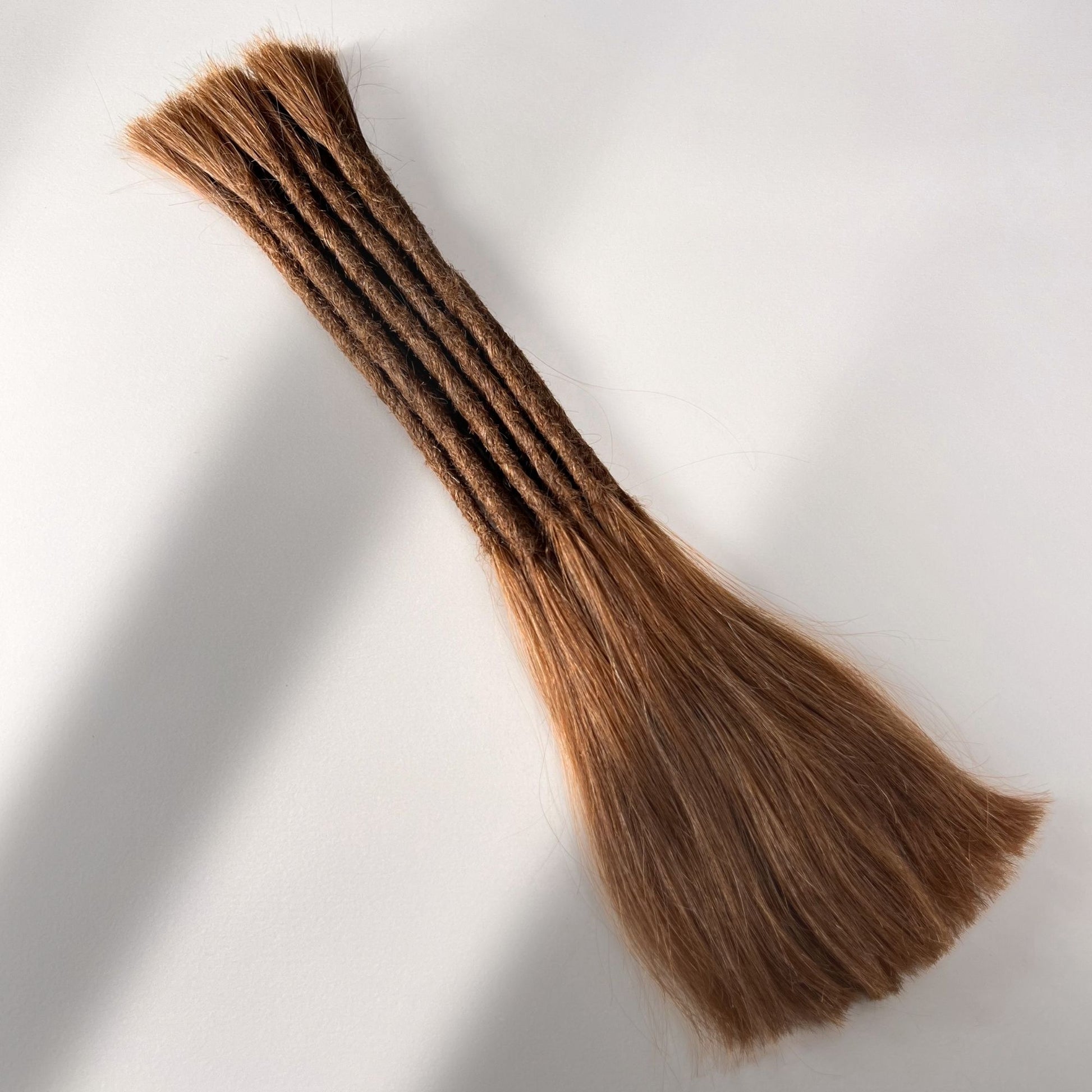 Full view of permanent straight loc extensions with long loose ends in Auburn Copper.