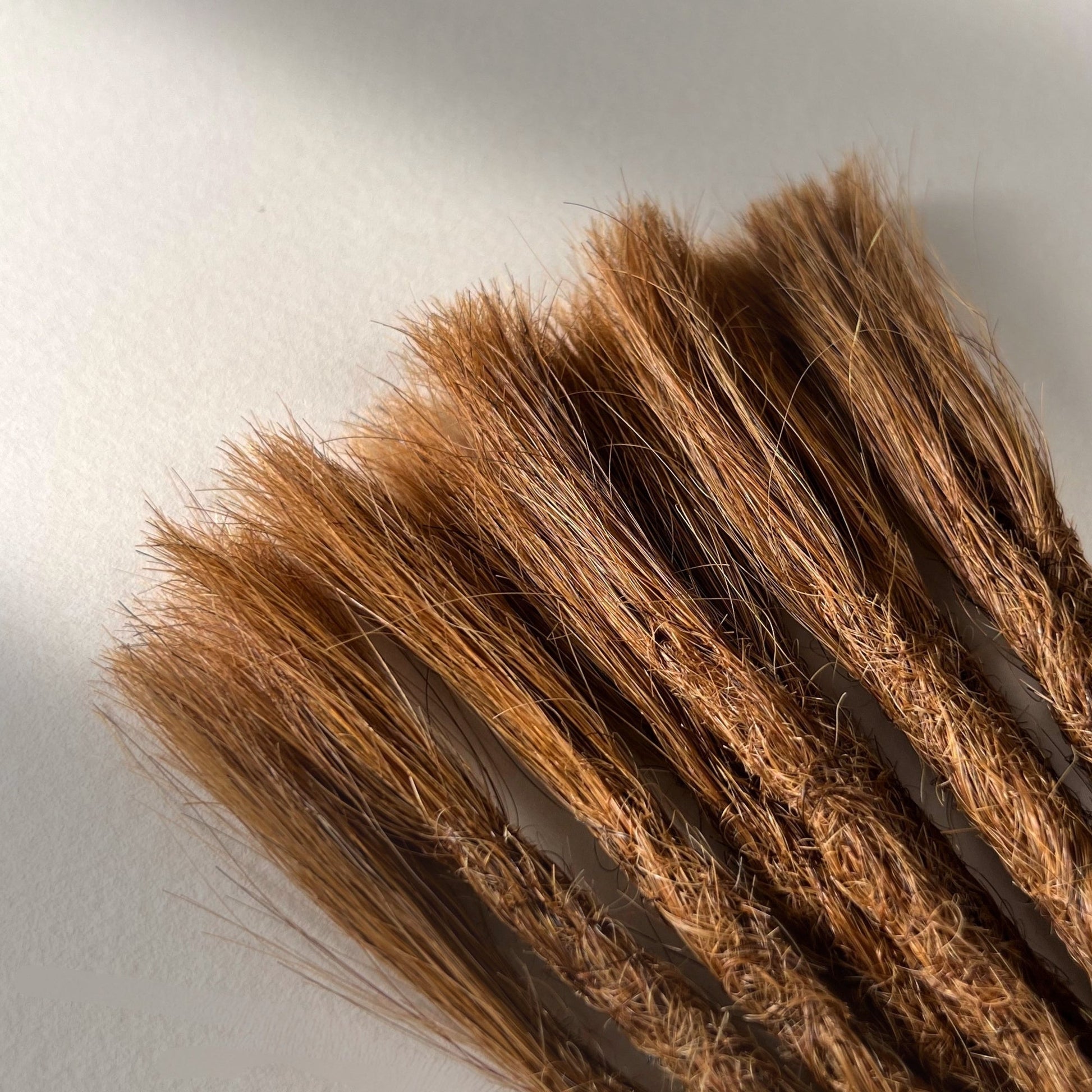 Connection point of permanent straight loc extensions in Auburn Copper.