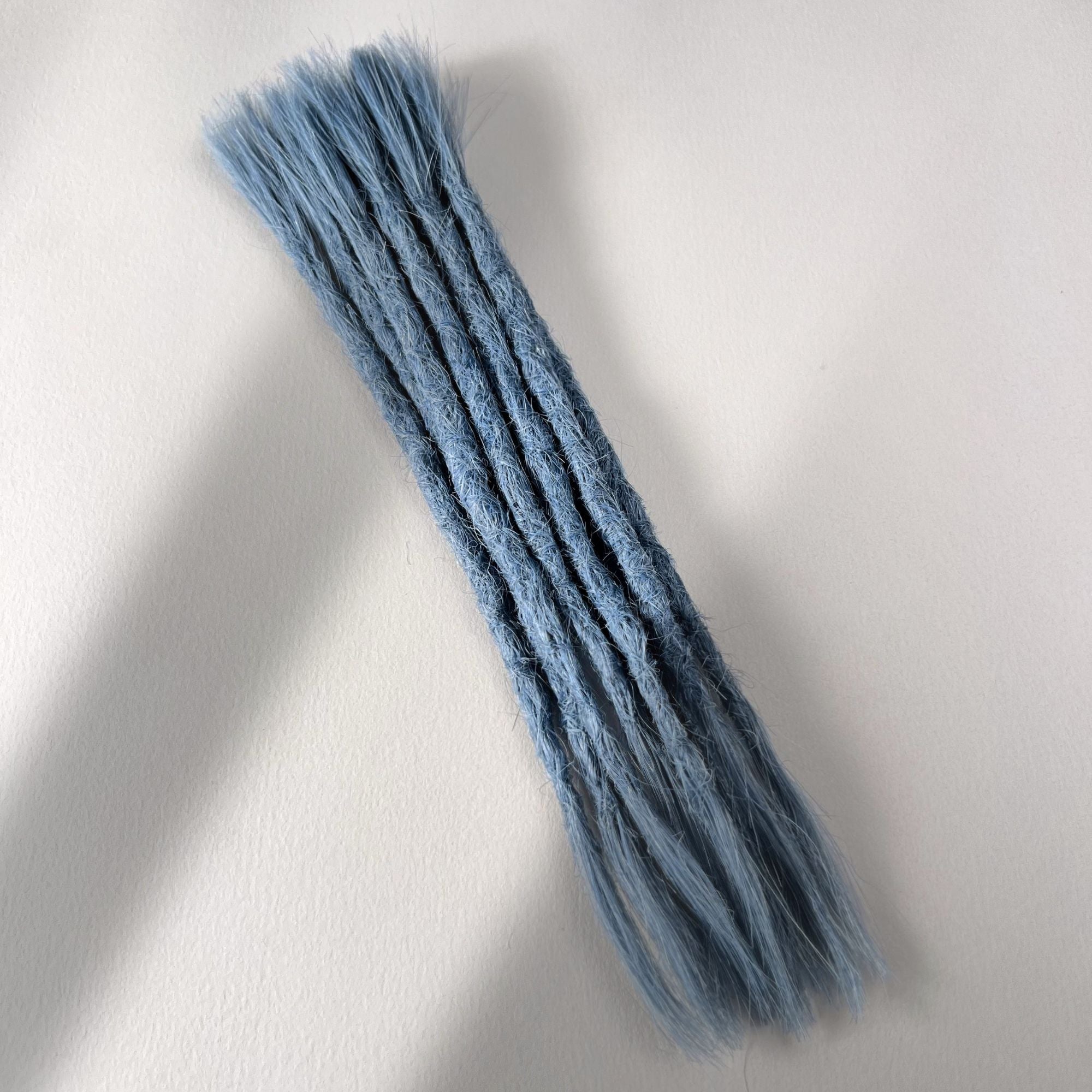 Full view of permanent straight loc extensions with open ends in Sky Blue.