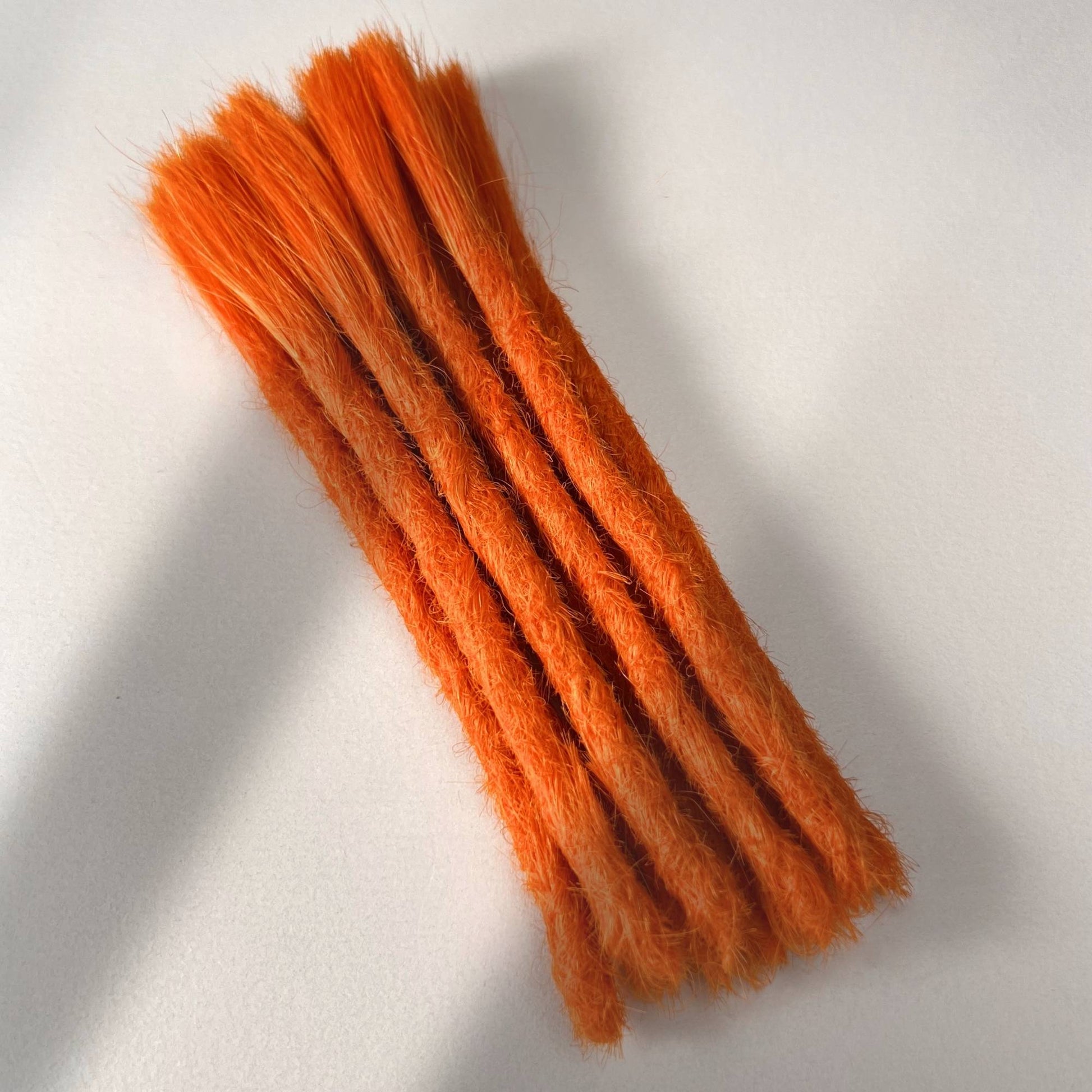 Full view of permanent straight loc extensions with blunt ends in Burnt Orange.