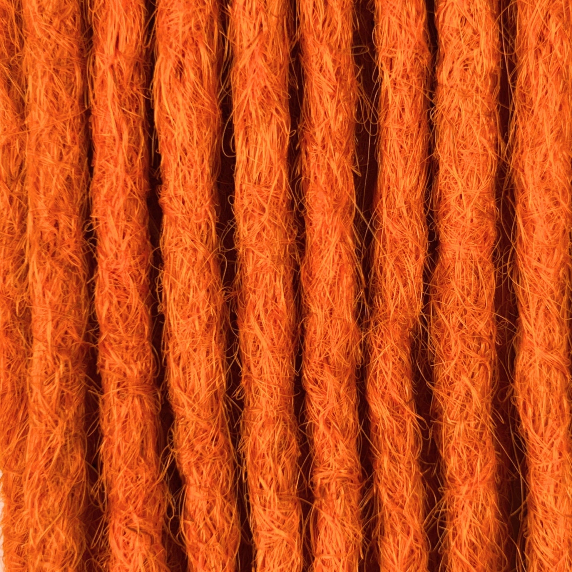 Close-up of straight loc extensions in Burnt Orange, showing the texture and color.