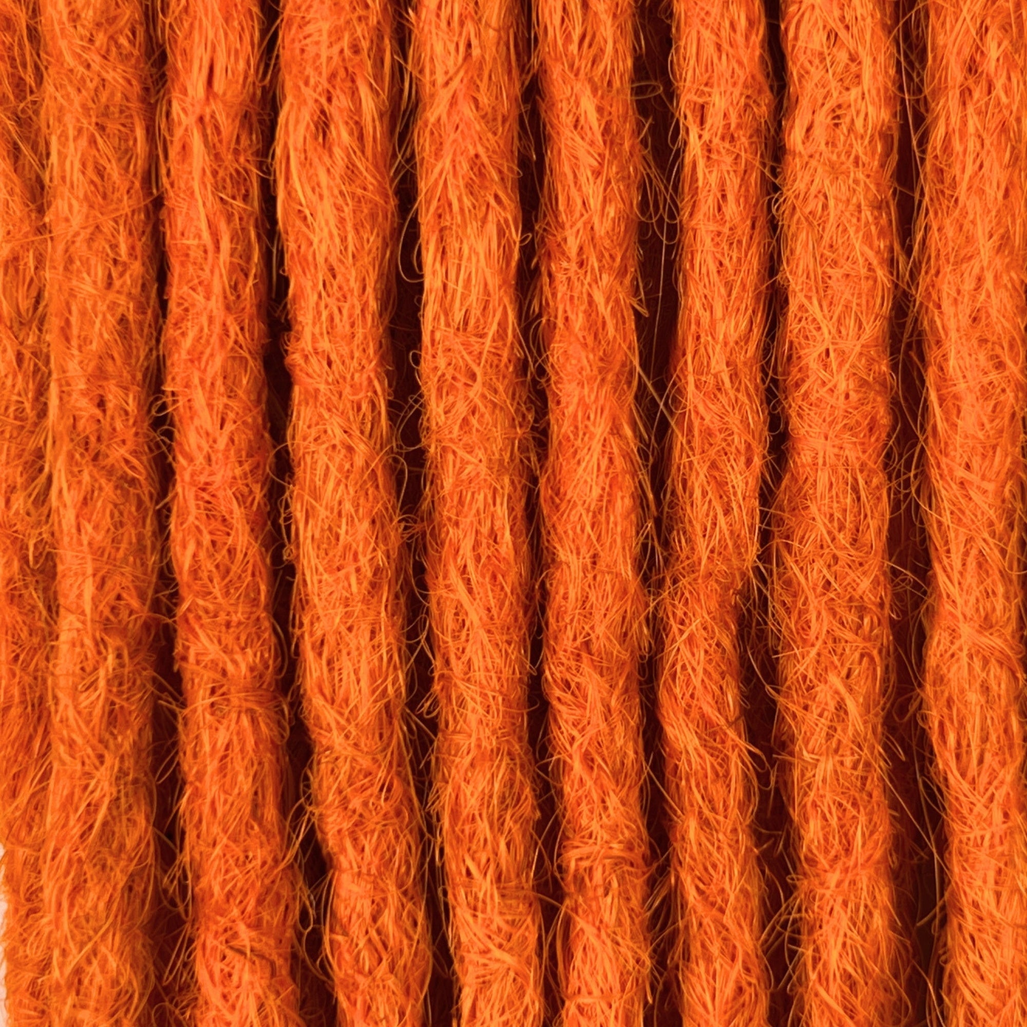 Close-up of straight loc extensions in Burnt Orange, showing the texture and color.