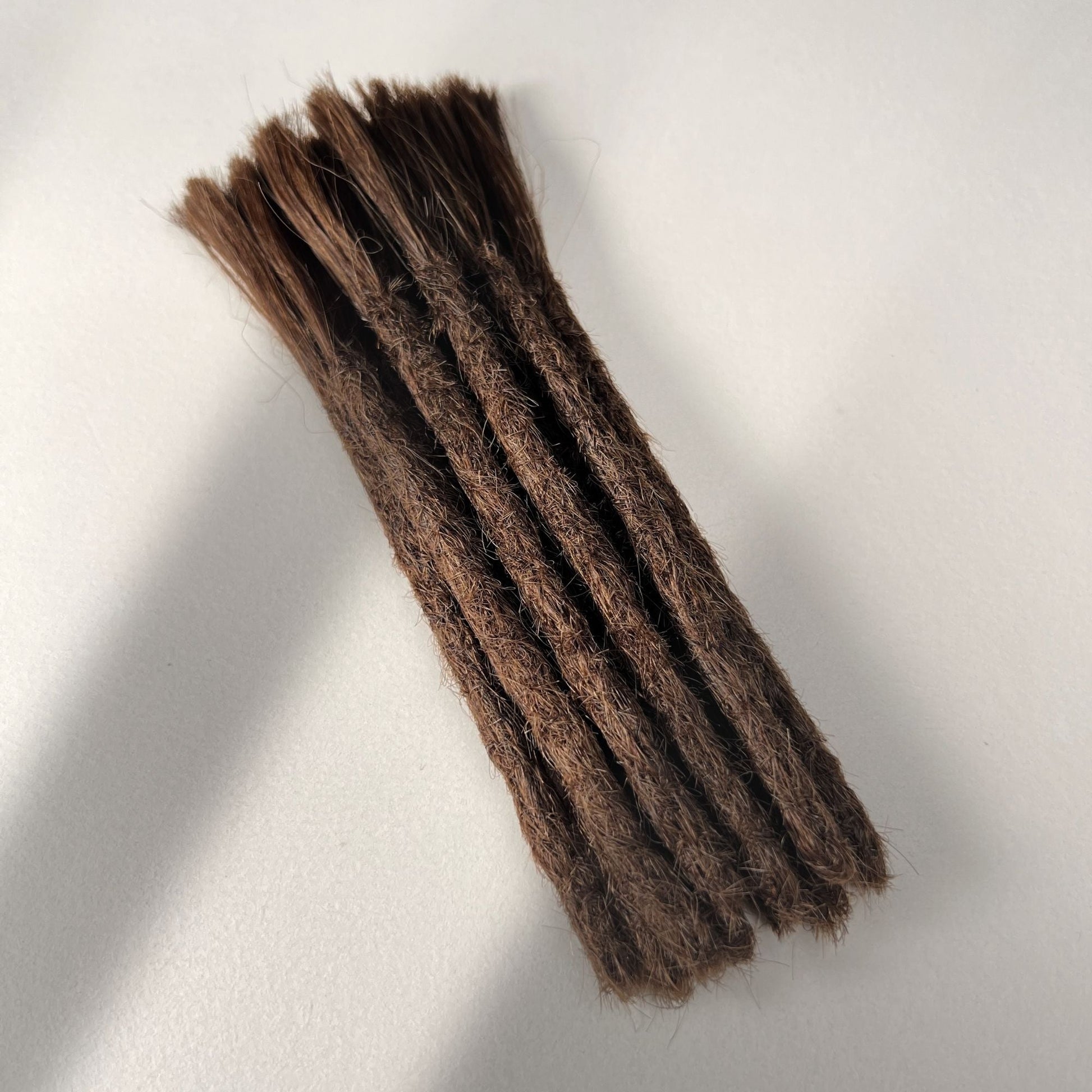 Full view of permanent straight loc extensions with blunt ends in Warm Cinnamon Brown.