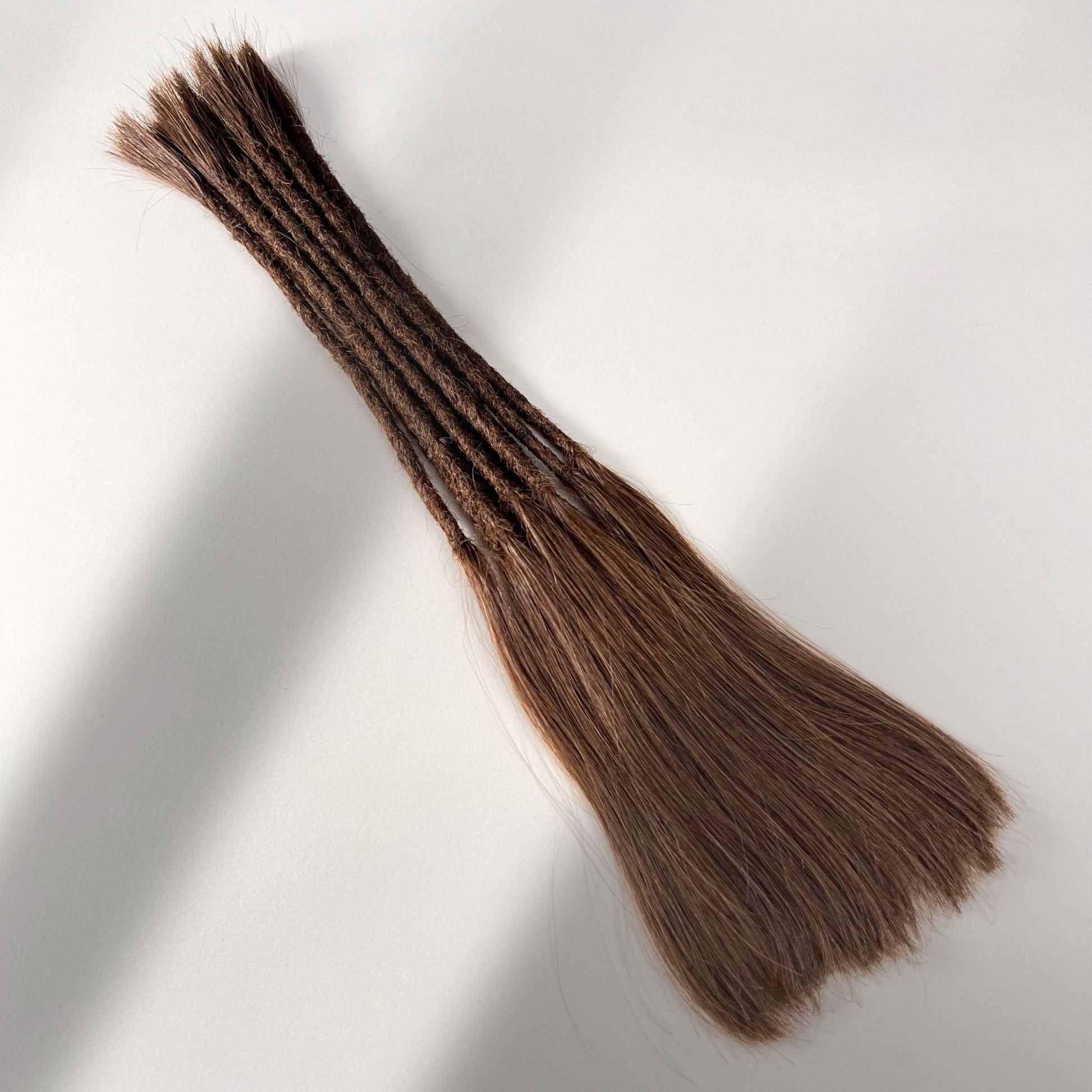 Full view of permanent straight loc extensions with long loose ends in Warm Cinnamon Brown.