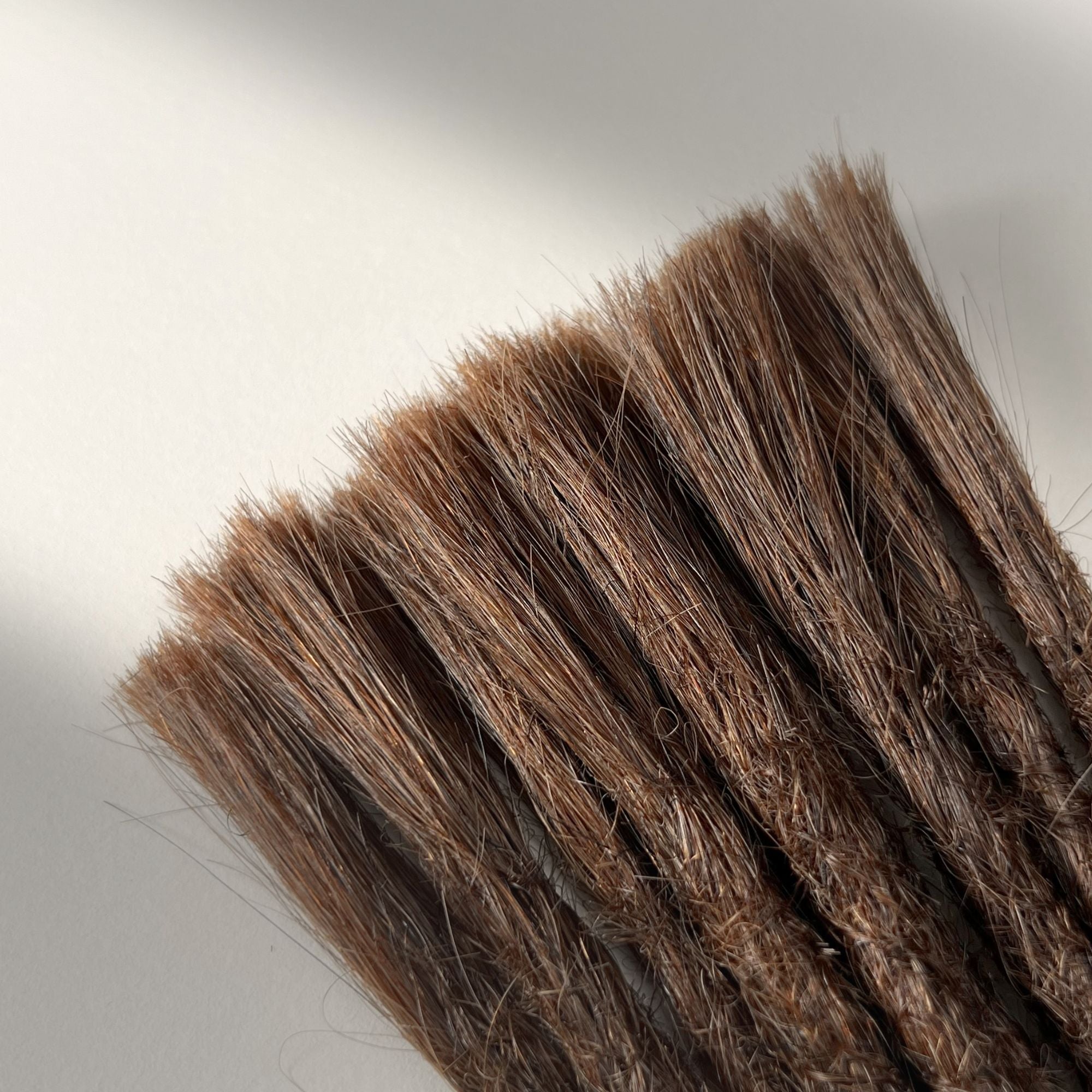 Connection point of permanent straight loc extensions with open ends in Spicy Cinnamon Brown.