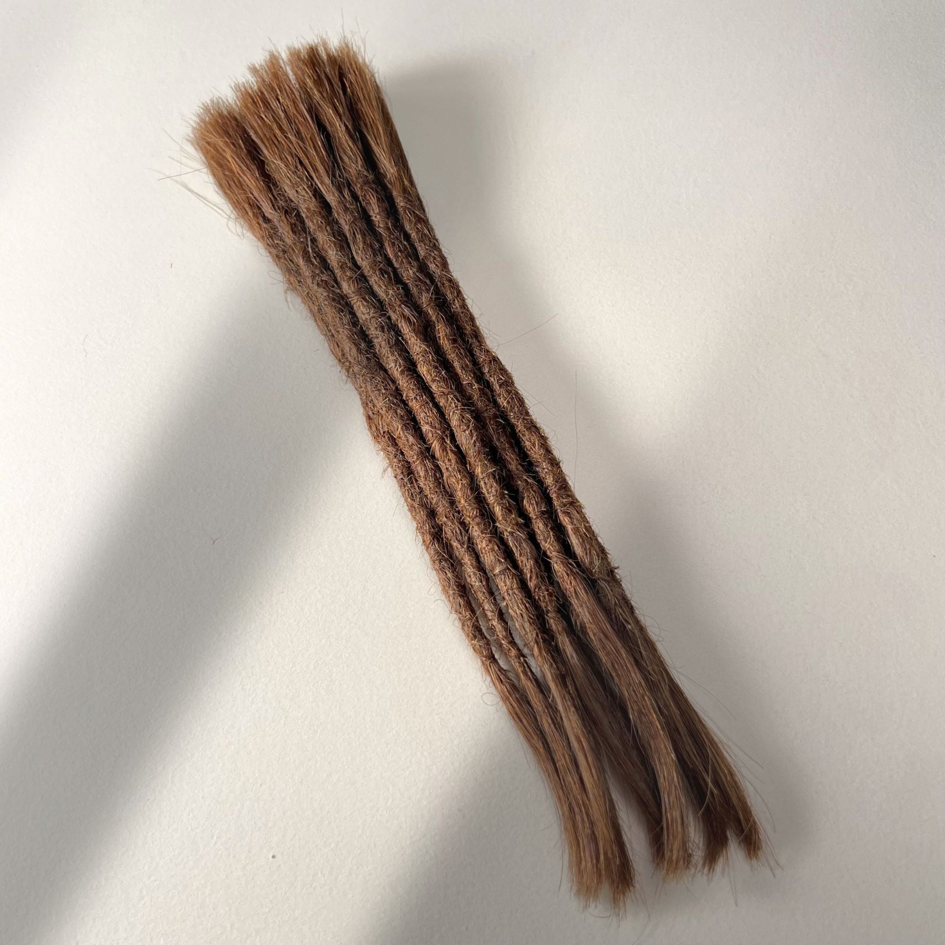 Full view of permanent straight loc extensions with open ends in Warm Cinnamon Brown.