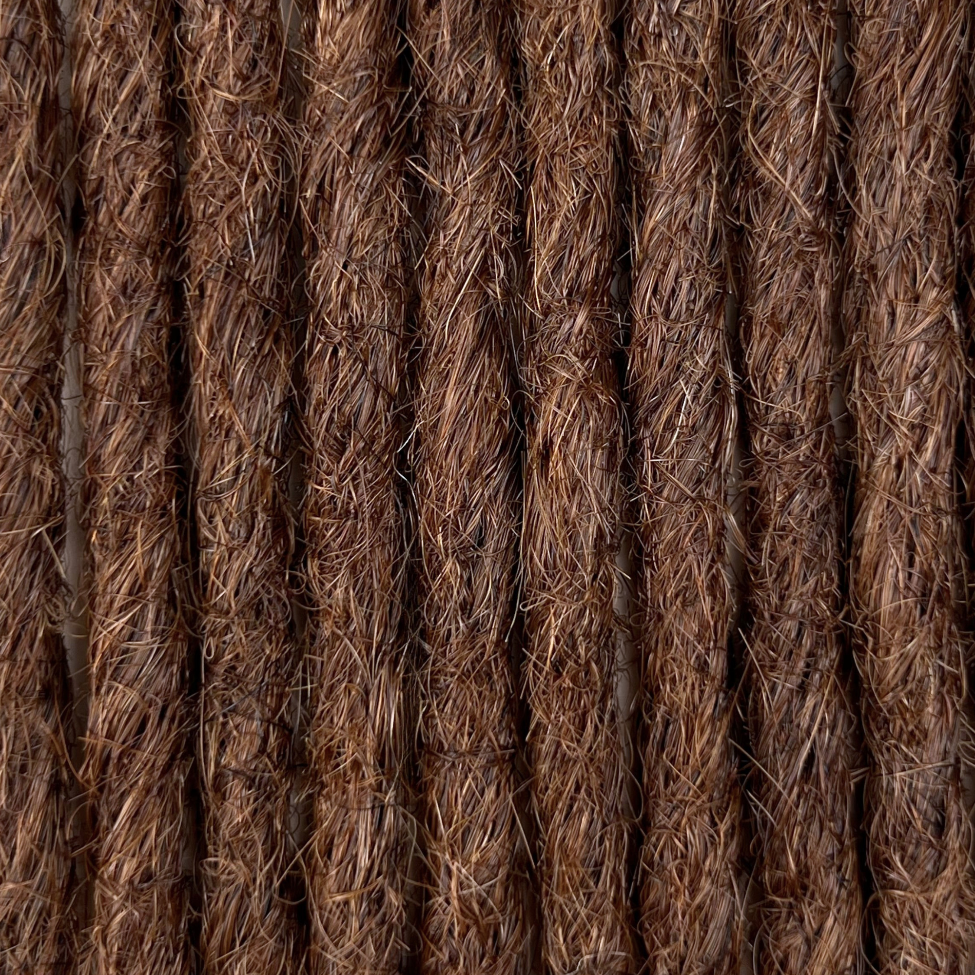 Close-up of straight loc extensions in Warm Cinnamon Brown, showing the texture and color.