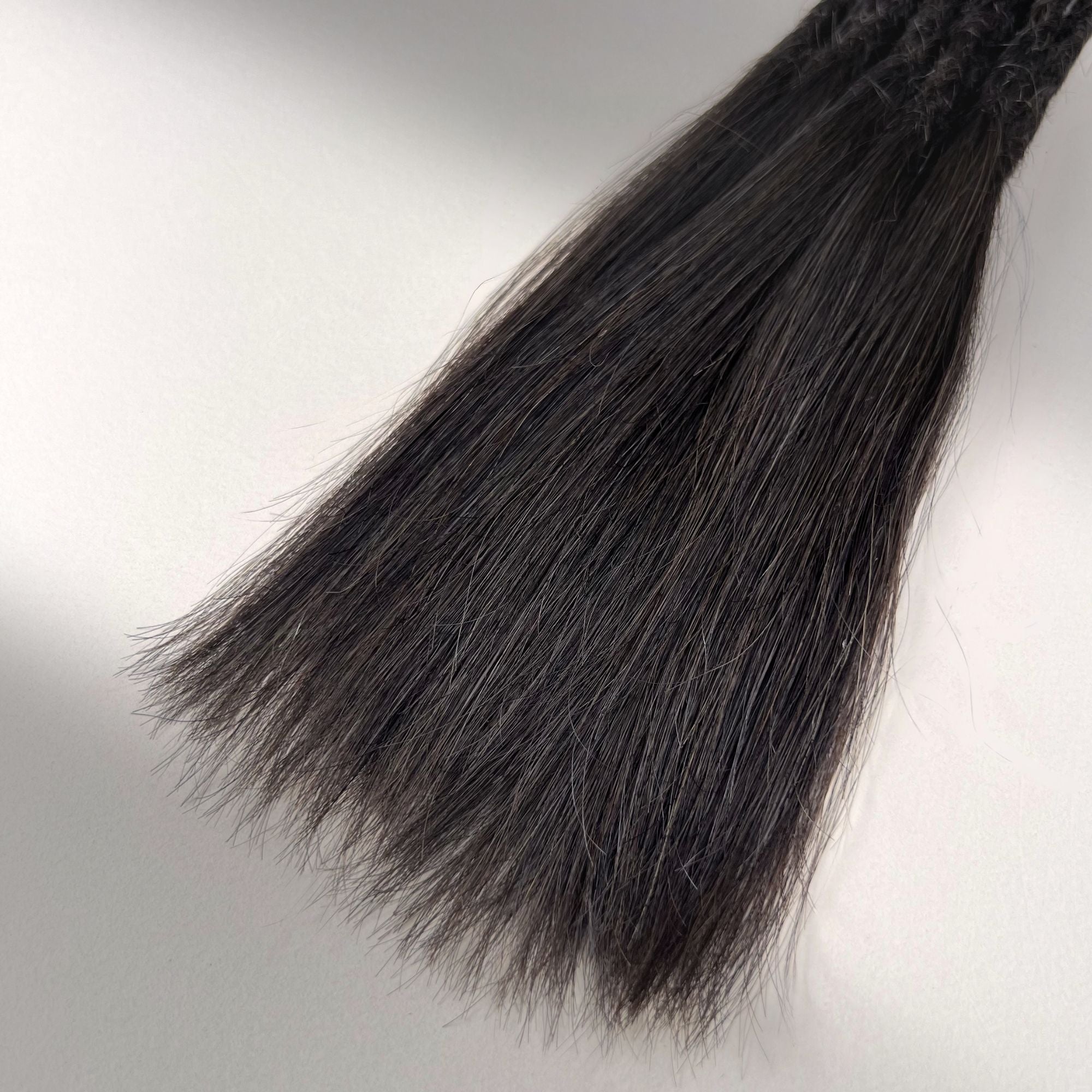 Tip detail of straight loc extensions with long loose ends in Warm Espresso Brown.